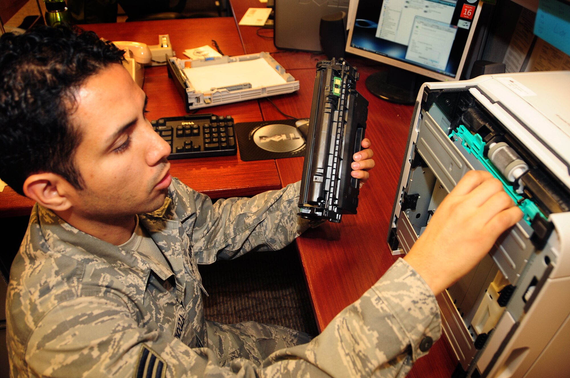 ELLSWORTH AIR FORCE BASE, S.D. -- Senior Airman Joshua Ortiz-Mendoza, 28th Mission Support Group client systems technician, removes an ink cartridge from a printer at the 37th Bomb Squadron in order to view inside, March 16.  Airman Ortiz-Mendoza checks all components of the printer in order to find the problem. U.S. Air Force photo/Airman 1st Class Anthony Sanchelli)
