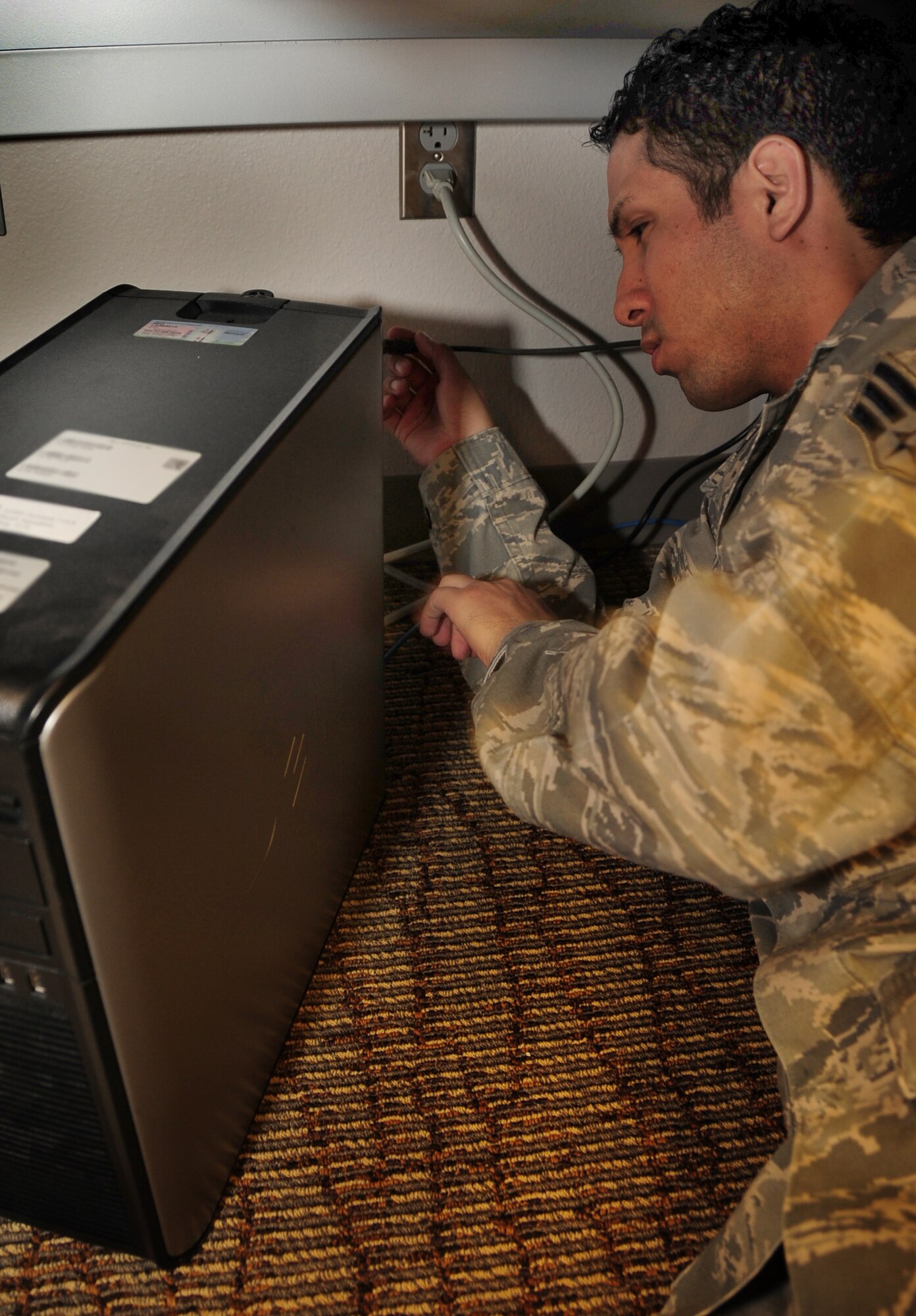 ELLSWORTH AIR FORCE BASE, S.D. -- Senior Airman Joshua Ortiz-Mendoza, 28th Mission Support Group client systems technician, checks the connection on a computer at the 37th Bomb Squadron, March 16.  Airman Ortiz-Mendoza works on a variety of computer related issues across base. U.S. Air Force photo/Airman 1st Class Anthony Sanchelli)


