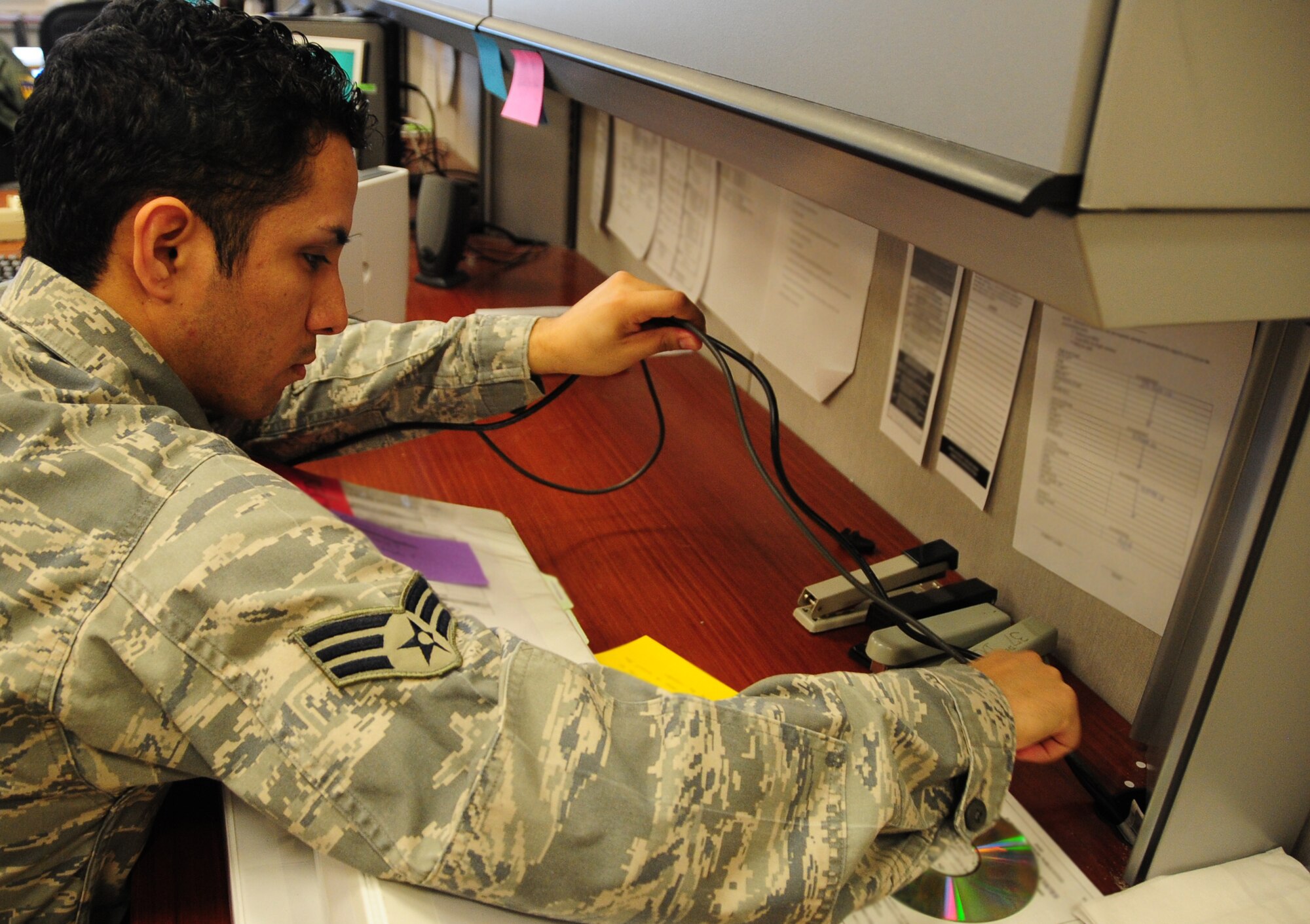 ELLSWORTH AIR FORCE BASE, S.D. -- Senior Airman Joshua Ortiz-Mendoza, 28th Mission Support Group client systems technician, connects a printer to a computer for testing at the 37th Bomb Squadron, March 16.  Airman Ortiz-Mendoza works on a variety of computer related issues across base. U.S. Air Force photo/Airman 1st Class Anthony Sanchelli)
