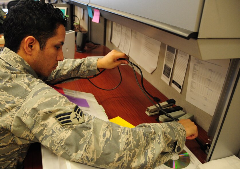 ELLSWORTH AIR FORCE BASE, S.D. -- Senior Airman Joshua Ortiz-Mendoza, 28th Mission Support Group client systems technician, connects a printer to a computer for testing at the 37th Bomb Squadron, March 16.  Airman Ortiz-Mendoza works on a variety of computer related issues across base. U.S. Air Force photo/Airman 1st Class Anthony Sanchelli)
