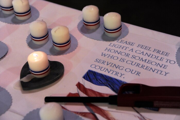 Attendees of the World War II Hanger Dance on the USS Yorktown in Mount Pleasant, S.C., light candles in honor of a veteran or someone who is currently serving in the military March 13, 2010. All proceeds from the event go toward the Honor Flight program. The flights leave from various cities around the United States and take World War II veterans to Washington D.C. for a day of sightseeing, remembering and honoring among its numerous memorials. (U.S. Air Force photo by Airman 1st Class Alexandra Hoachlander)(Released)
