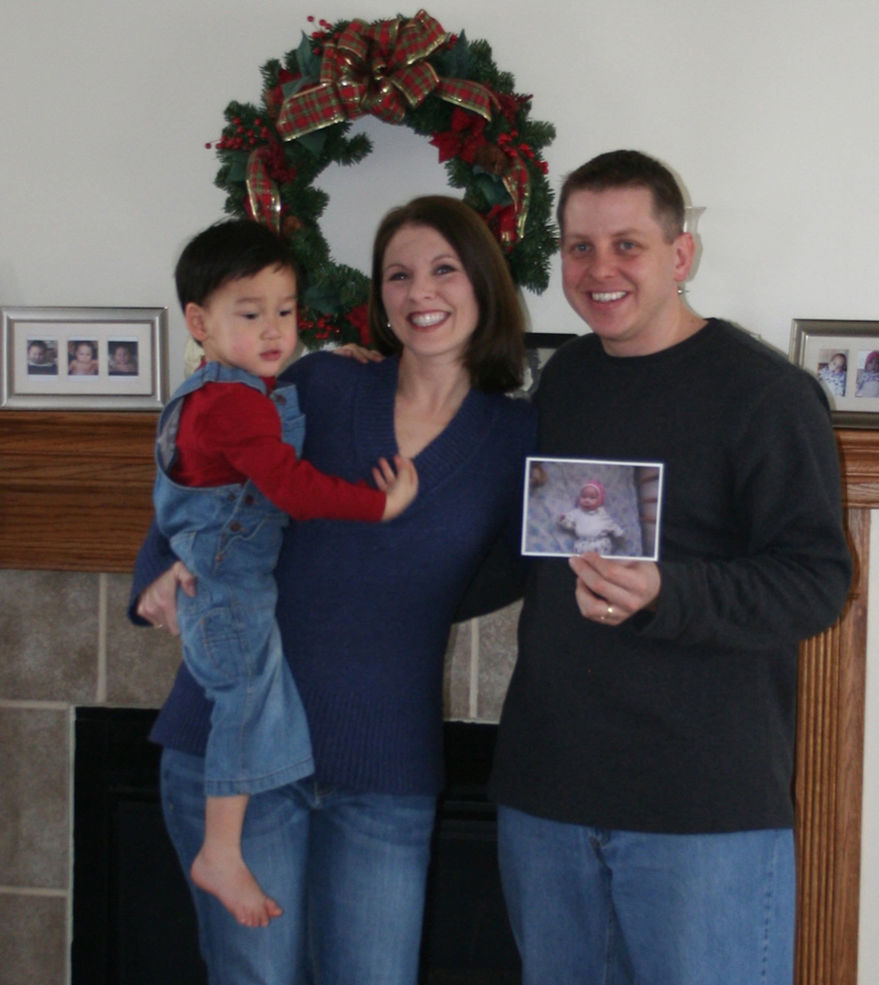 WRIGHT-PATTERSON AIR FORCE BASE, Ohio – Capt. Scott and Kami DeBoer (holding Kaleb), wait for news at their home in Fairborn, Ohio, on when they can bring  the child they are waiting to adopt, Tate, (in the photo that Captain DeBoer is holding), home from Kyrgyzstan. (U.S. Air Force photo/Stacy Vaughn)