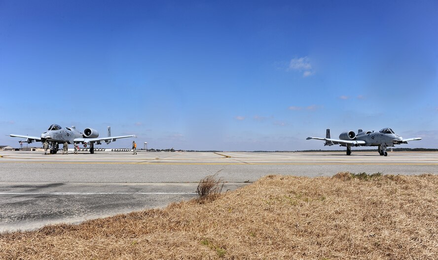 MOODY AIR FORCE BASE, Ga. -- Airmen from the 23rd Aircraft Maintenance Squadron perform final checks on two A-10C Thunderbolt II aircraft before final takeoff here March 3. The process involves removing lock pins, tire blocks and arming the jet’s weapons, as well as ensuring there are no safety issues with the aircraft. (U.S. Air Force photo by Airman 1st Class Joshua Green)