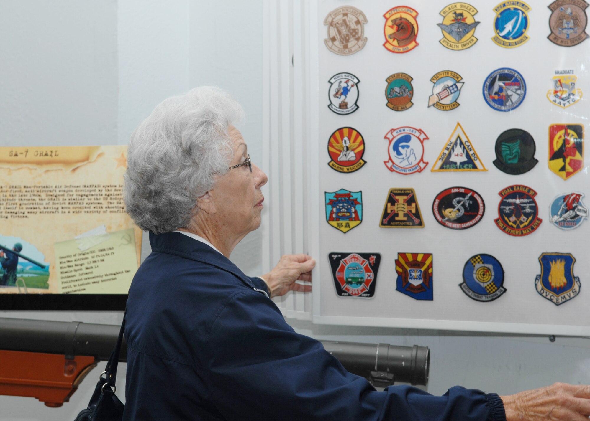 Eileen Sanders, wife of retired Lt. Col. Elwood Sanders, flips through pages of unit patches at the Threat Training Facility, March 6, 2010, at Nellis Air Force Base, Nev. (U.S. Air Force photo/2nd Lt. Emily Chilson)