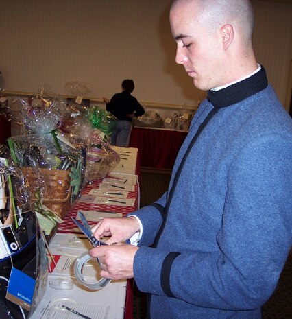 Cadet Andrew Goodson helps sets up for the Team Charleston Spouses? Club ?Silent Auction Scholarship Roundup" March 13 at the Charleston Club. The TCSC hosted the auction to raise money for scholarships which will be awarded to military dependents seeking higher education. Cadet Goodson is currently enrolled at The Citadel in Charleston, S.C. (Courtesy photo)