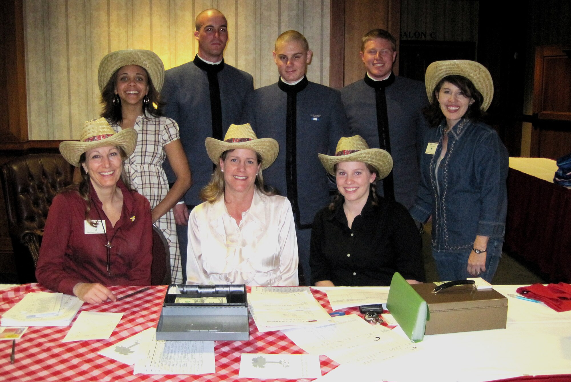 Team Charleston Spouses' Club board members worked with cadet volunteers from The Citadel to make the ?Silent Auction Scholarship Roundup? held at the Charleston Club a success March 13. More than 60 donated items were put up for silent bid and approximately 15 via live auction to raise funds for scholarships. The mission of the TCSC is to bring spouses together for social, charitable and educational purposes. (Courtesy photo)