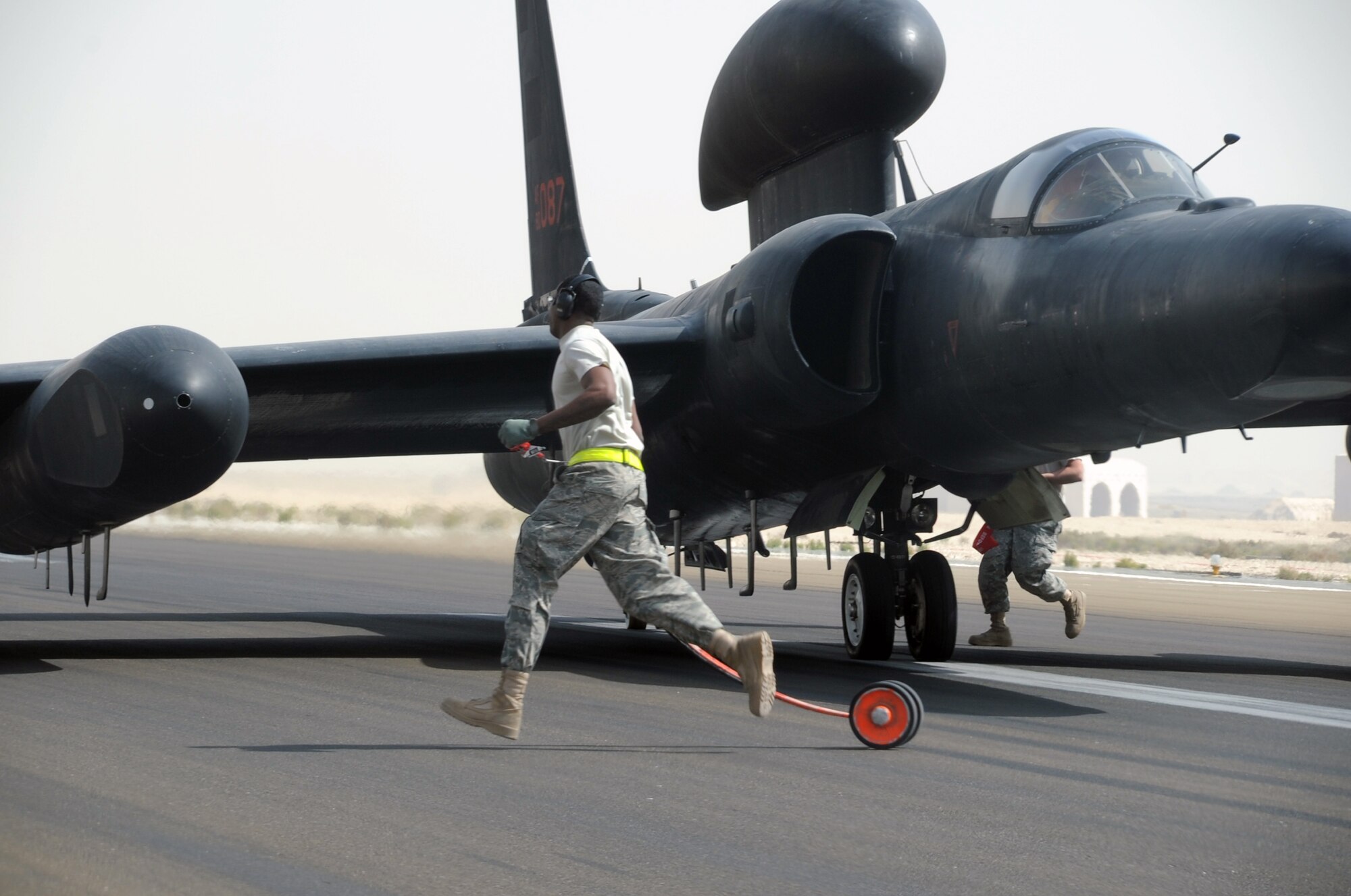 U-2 Dragon Lady maintenance Airmen from the 380th Expeditionary Aircraft Maintenance Squadron Dragon aircraft maintenance unit move to place wing wheels on a U-2  being guided by Maj. William Gottenberg, U-2 pilot with the 99th Expeditionary Reconnaissance Squadron, during operations at a non-disclosed base in Southwest Asia on March 9, 2010. Major Gottenberg and the U-2 maintenance Airmen are deployed from Beale Air Force Base, Calif. (U.S. Air Force Photo/Master Sgt. Scott T. Sturkol/Released)