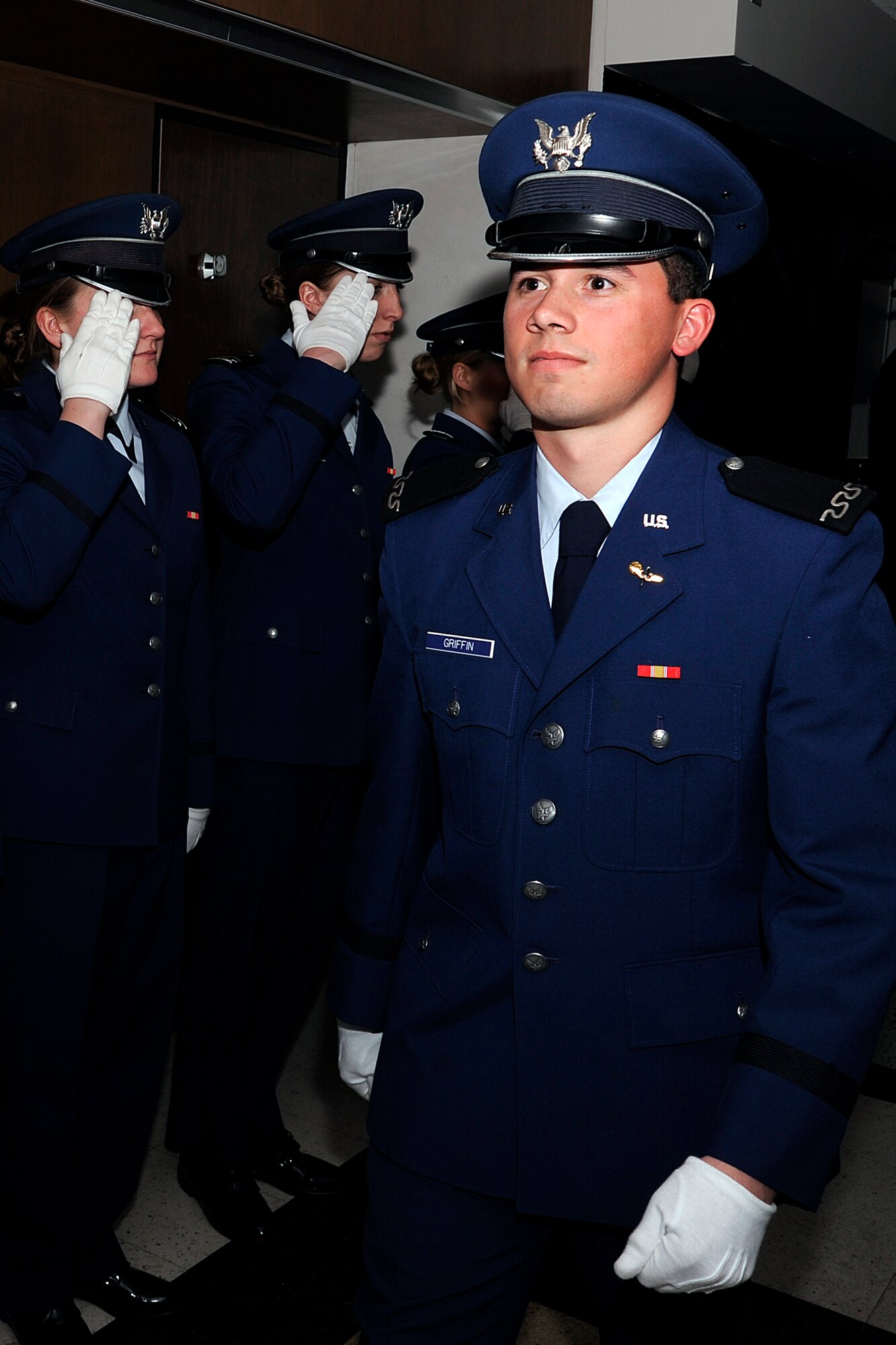 Cadet 4th Class Michael Griffin of marches down the darkened hallways of Cadet Squadron 18 as upperclassmen salute him in the time-honored tradition of the Props and Wings Ceremony Mar. 13 during Recognition Events.  Recognition consists of several days of mentally and physically demanding activities, and culminates with the ascension of the freshmen into the ranks of upper class cadets. (Air Force Photo/Mike Kaplan)
