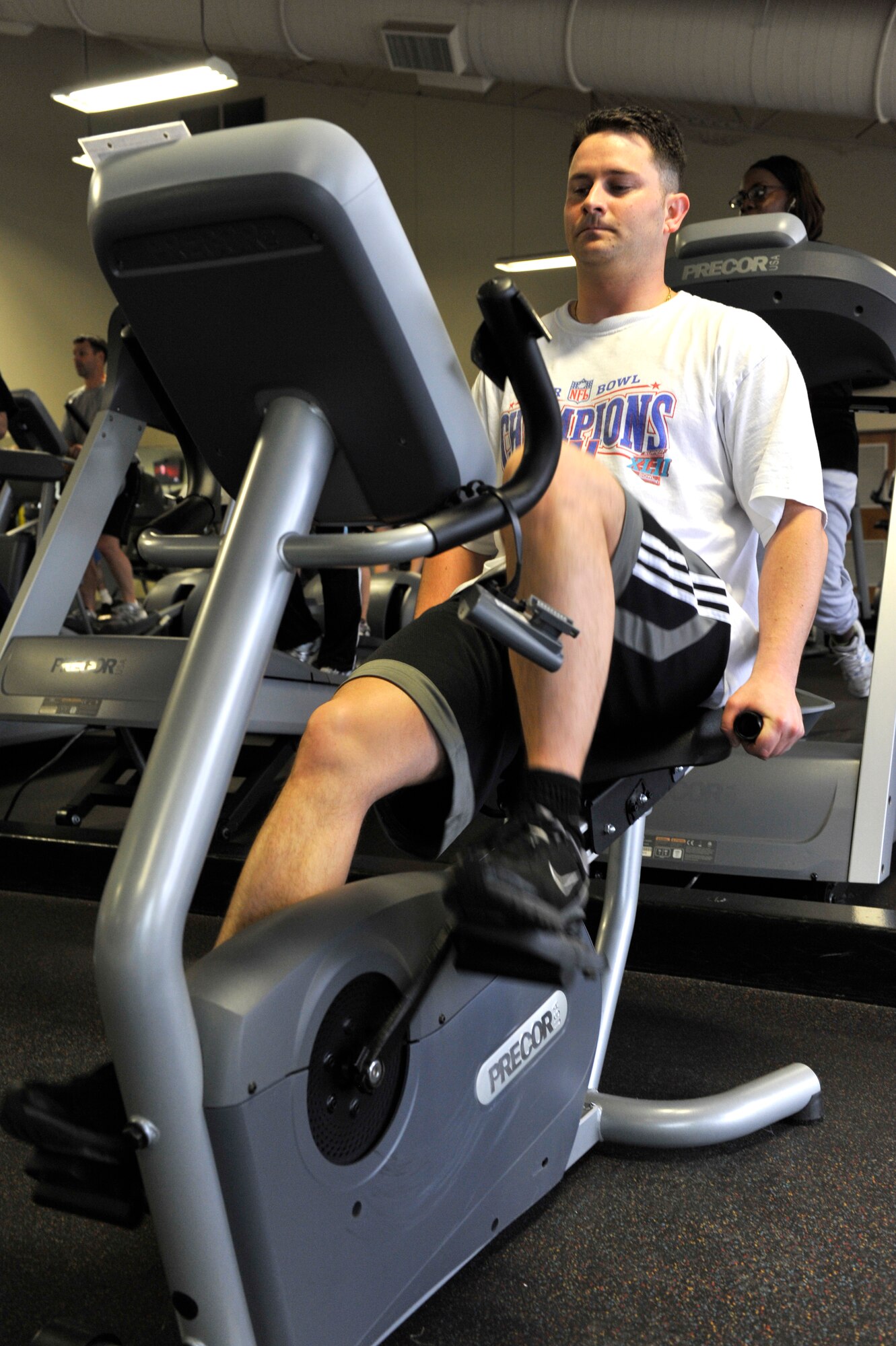 Tech. Sgt. Brandon Guthinger, 714th Training Squadron flight engineer student, exercises using the stationary bike at the fitness center. The Cardio room has treadmills, stationary bikes, stair steppers and elliptical machines for people to use for a cardio workout. (U.S. Air Force photo by Senior Airman Christine Clark)