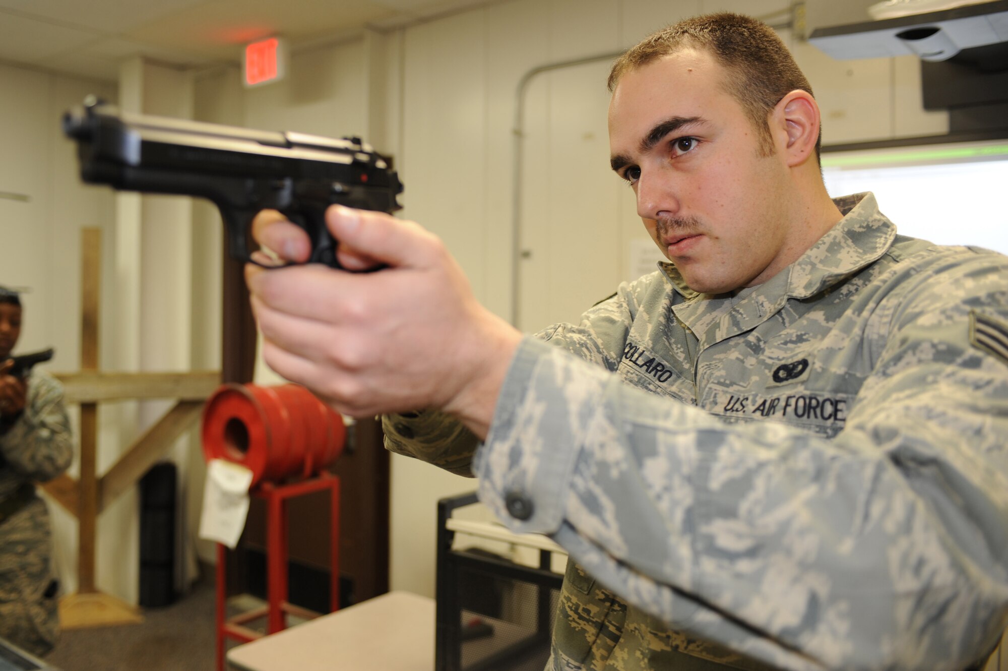 WHITEMAN AIR FORCE BASE, Mo. - Senior Airman Robert Collaro, 509th Security Forces Squadron combat arms instructor, demonstrates proper procedure and hand grip for an M-9 pistol the Combat Arms Training and Maintenance facility here, March 16, 2010.(U.S. Air Force photo by Airman 1st Class Carlin Leslie )(Released)
