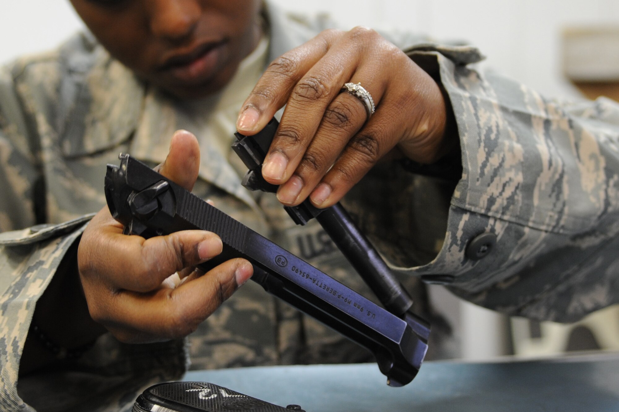 WHITEMAN AIR FORCE BASE, Mo. -  A 509th Security Forces Squadron Airman disassembles an M-9 pistol during combat arms training here, March 16, 2010.(U.S. Air Force photo by Airman 1st Class Carlin Leslie)(Released)


