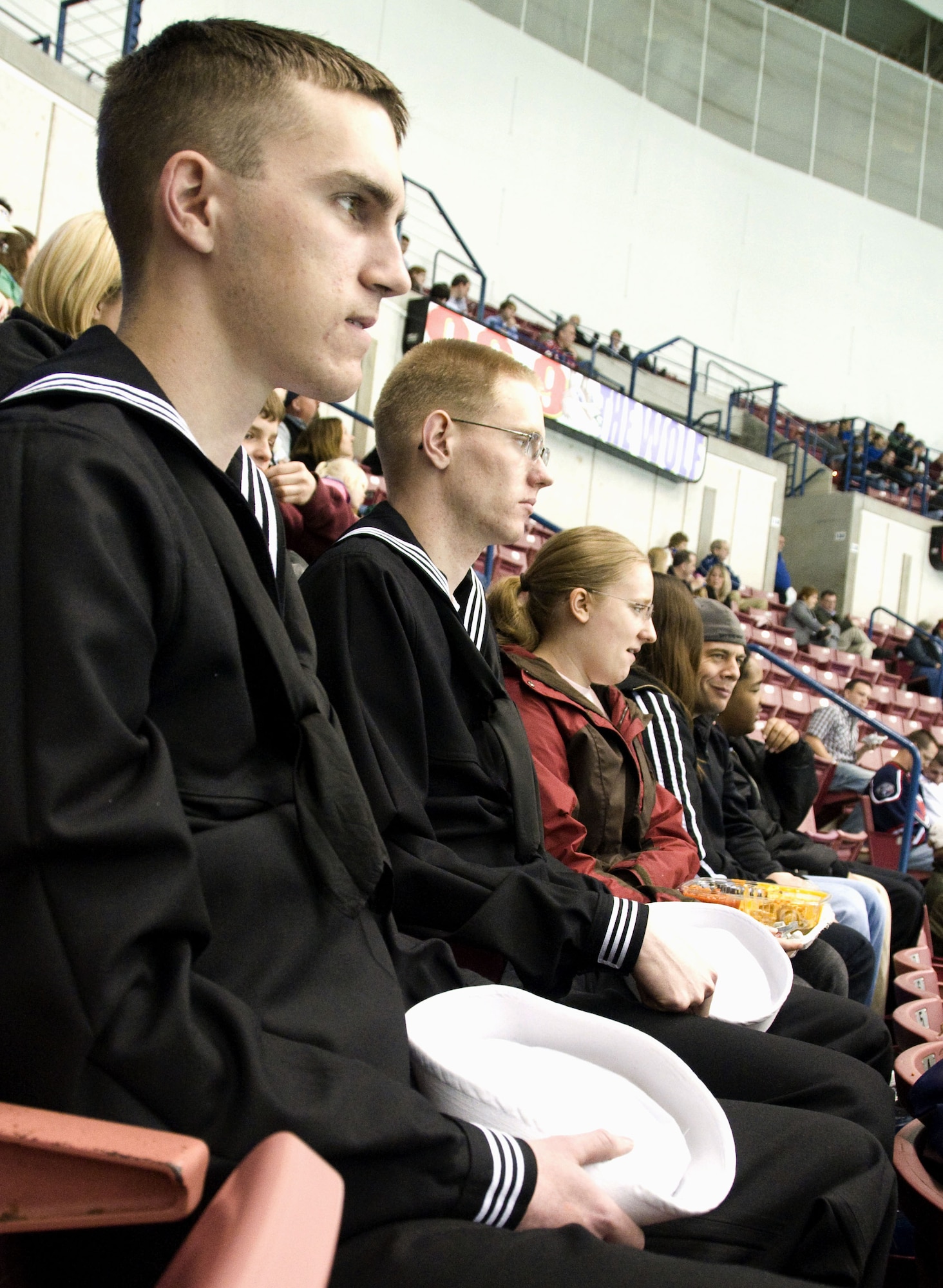 Navy Fireman Jake Rynning, left, and Navy Fireman Justin Griffin and his wife Malinda enjoy free seats to the South Carolina Stingrays military appreciation hockey game at the North Charleston Coliseum March 12. The Stingrays donated approximately 1,000 tickets for the game to military bases in and around Charleston, Beaufort and Columbia. Firemen Rynning and Griffin are enrolled in training to become machinists mates at Naval Weapons Station Charleston. (U.S. Air Force photo/Staff Sgt. Daniel Bowles)
