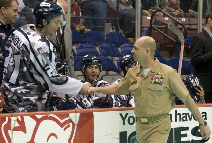 Navy Cmdr. Gary Martin shakes hands with defenseman Johann Kroll after the opening ceremony for the South Carolina Stingrays military appreciation night at the North Charleston Coliseum March 12. The event was held on a critical game for the team to enter the playoff season, with free tickets provided to military members serving at bases throughout South Carolina. Commander Martin is the Naval Weapons Station Charleston commanding officer. (U.S. Air Force photo/Staff Sgt. Daniel Bowles)