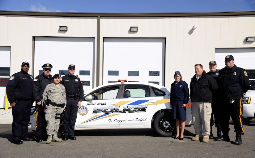 Left to right- Officer Barry Terrell, Sgt. Gary Gassert, Airman 1st Class Alexis Kawar, Officer Dusty Connelly, Col. Gina Grosso,Matt Curry, unit resource advisor, Maj. James Dove, and Sgt. Danny Colon stop for a photo-op in front of a new JB MDL police vehicle March 1. (U.S. Air Force photo/ Carlos Cintron)
