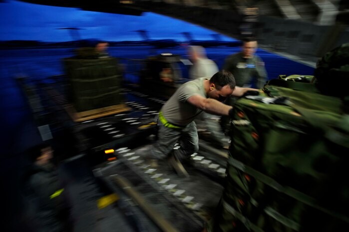 Tech. Sgt. Sean Stottlemyer pushes the forth of five air delivery bundles onto a Charleston C-17 on the flightline here March 11. The bundles were equipped with the Firefly Joint Precision Air Delivery System, or JPADS, which is used in conjunction with a global positioning satellite sensor dropped from the aircraft during flight to relay data back to the aircraft, allowing for precision air delivery of the bundles. Sergeant Stottlemyer is a shift supervisor with the 437th Aerial Port Squadron. (U.S. Air Force photo/Tech. Sgt. Dennis Henry)