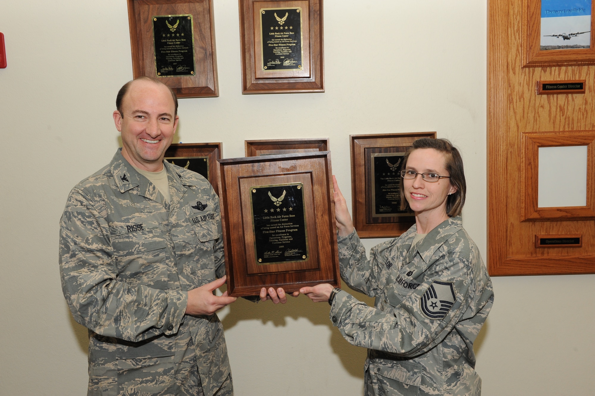 Col. George Risse, 19th Mission Support Group commander, presents Master Sgt. Christina Taylor, 19th Force Support Squadron fitness and sports director, with the Five-Star Fitness Program Award March 11 at the base fitness center. The base fitness center and personnel were evaluated on five categories: operations, programs, training, facilities and customer service. (U.S. Air Force photo by Senior Airman Ethan Morgan)