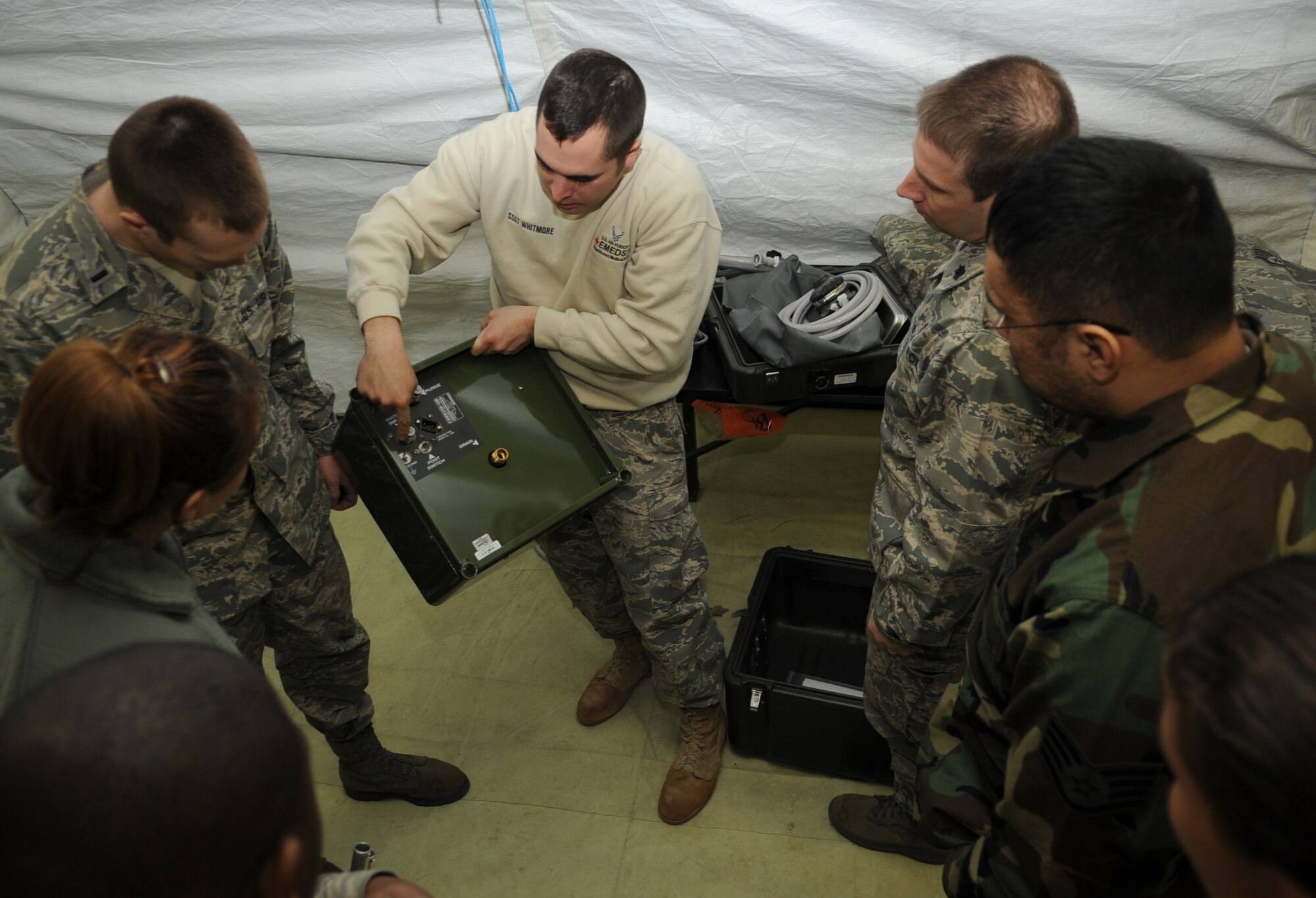 U.S. Air Force Staff. Sgt. Lawrence Whitmore, School of Aerospace Medicine instructor and medical technician, from Brooks City-Base, Texas, demonstrates the proper way to set up a sink inside of a tent during the facility population training, Ramstein Air Base, Germany, March 16, 2010. The Expeditionary Medical Support (EMEDS) Mobile Course teaches and evaluates corps specific field situations as well as offers updates in Air Force Medical Service concept of operations and doctrine. It also teaches setup and packing out of a field EMEDS compound, deployed operations, field medical, nursing and operational support equipment proficiency, field exercises to both emphasize and evaluate learning of concepts taught. (U.S. Air Force photo by Airman 1st Class Caleb Pierce)