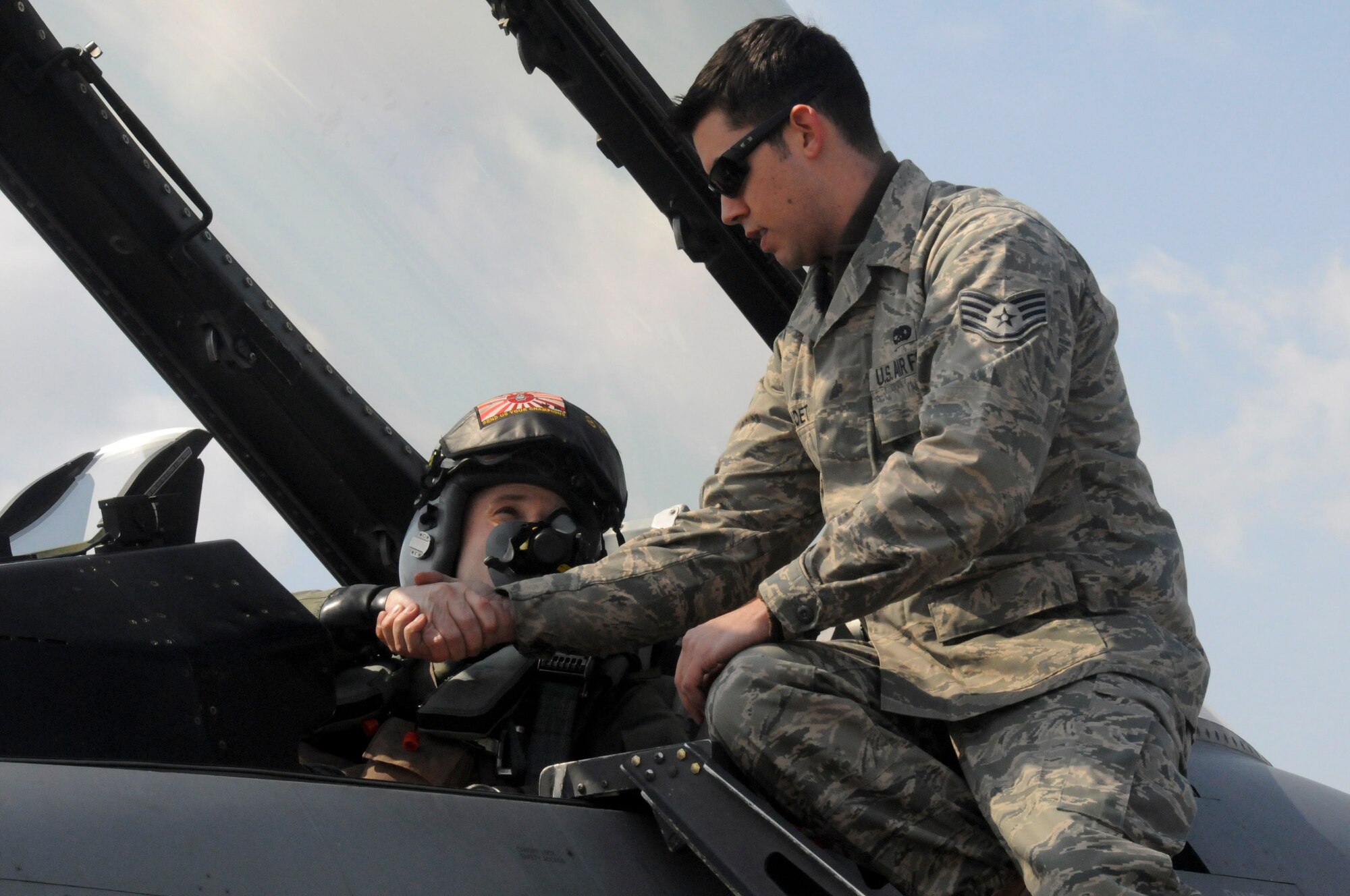 TSUIKI AIR BASE, Japan -- Staff Sgt. Christopher Audet, 35th Maintenance Squadron crewchief, shakes hands with Capt. Matt Kenkel, 14th Fighter Squadron pilot, prior to takeoff March 11. Approximately 90 Airmen and five F-16 Fighting Falcons were at Tsuiki to participate in an aviation training relocation exercise with the Japan Air Self-Defense Force. (U.S. Air Force photo/Staff Sgt. Rachel Martinez)