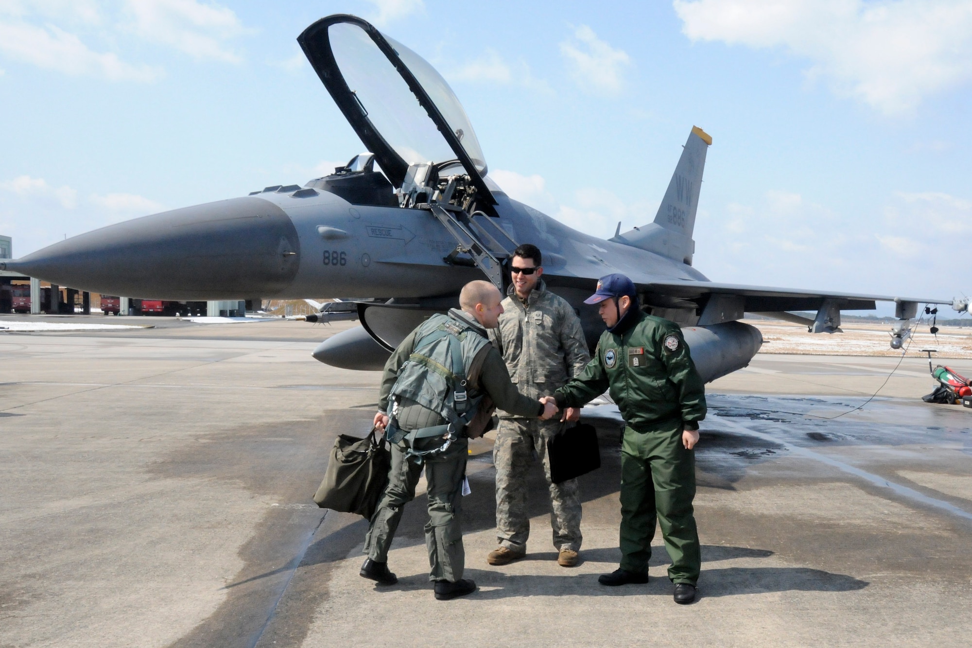 TSUIKI AIR BASE, Japan -- Capt. Matt Kenkel, 14th Fighter Squadron pilot, greets his two crewchiefs, Staff Sgt. Christopher Audet and Japan Air Self-Defense Force Staff Sgt. Yuuta Isoya, prior to taking off for a training mission against JASDF F-15 aircraft during an aviation training relocation exercise March 11. The ATR provided dissimilar air training for pilots and a cross-familiarization program for select Airmen. (U.S. Air Force photo/Staff Sgt. Rachel Martinez)