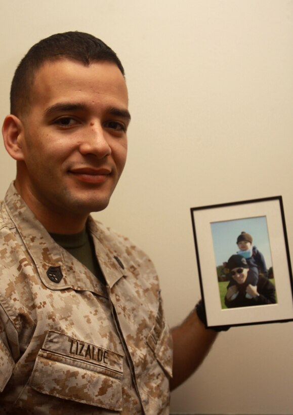 Staff Sgt. Trinity A Lizalde holds a photo of him and his son, Diego, after his discharge from the hospital March 19 on Camp H.M. Smith, Hawaii. Lizalde's son contracted leukemia Nov. 9, 2007. His family was forced to move from Okinawa, Japan to Hawaii after living there for only six weeks to save their son. Facing financial hardship due to the move, Lizalde turned to the Navy Marine Corps Relief society for help and they paid 50 percent of his debt. Lizalde is the embark chief and NMCRS battalion coordinator for Headquarters and Service Battalion, U.S. Marine Corps Forces, Pacific.