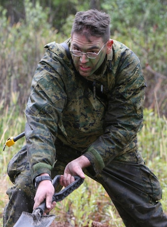 A Marine with Military Police Company, Combat Logistics Regiment 27, 2nd Marine Logistics Group, battles with the rain as he refills a fighting hole after finishing a four-day field exercise aboard Camp Lejeune, N.C., March 18, 2010.  The purpose of the field exercise was to ensure that all of the field military policemen are prepared for possible upcoming deployments to Afghanistan.  (U.S. Marine Corps photo by Lance Cpl. Melissa A. Latty)
