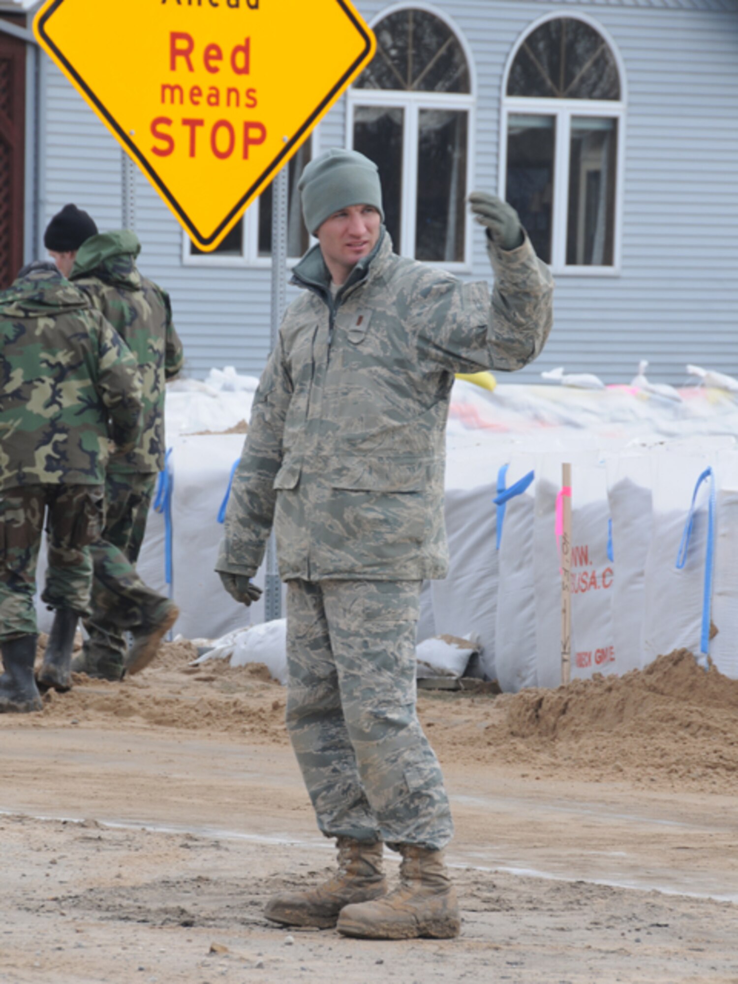 2nd Lt. Shawn Muehler, of the North Dakota Air National Guard, directs a flood fighting equipment into place March 18, Fargo, N.D.  Muehler is part of team that is filling and placing large sandbags into place to create a flood barrier from the rising water of the Red River. 