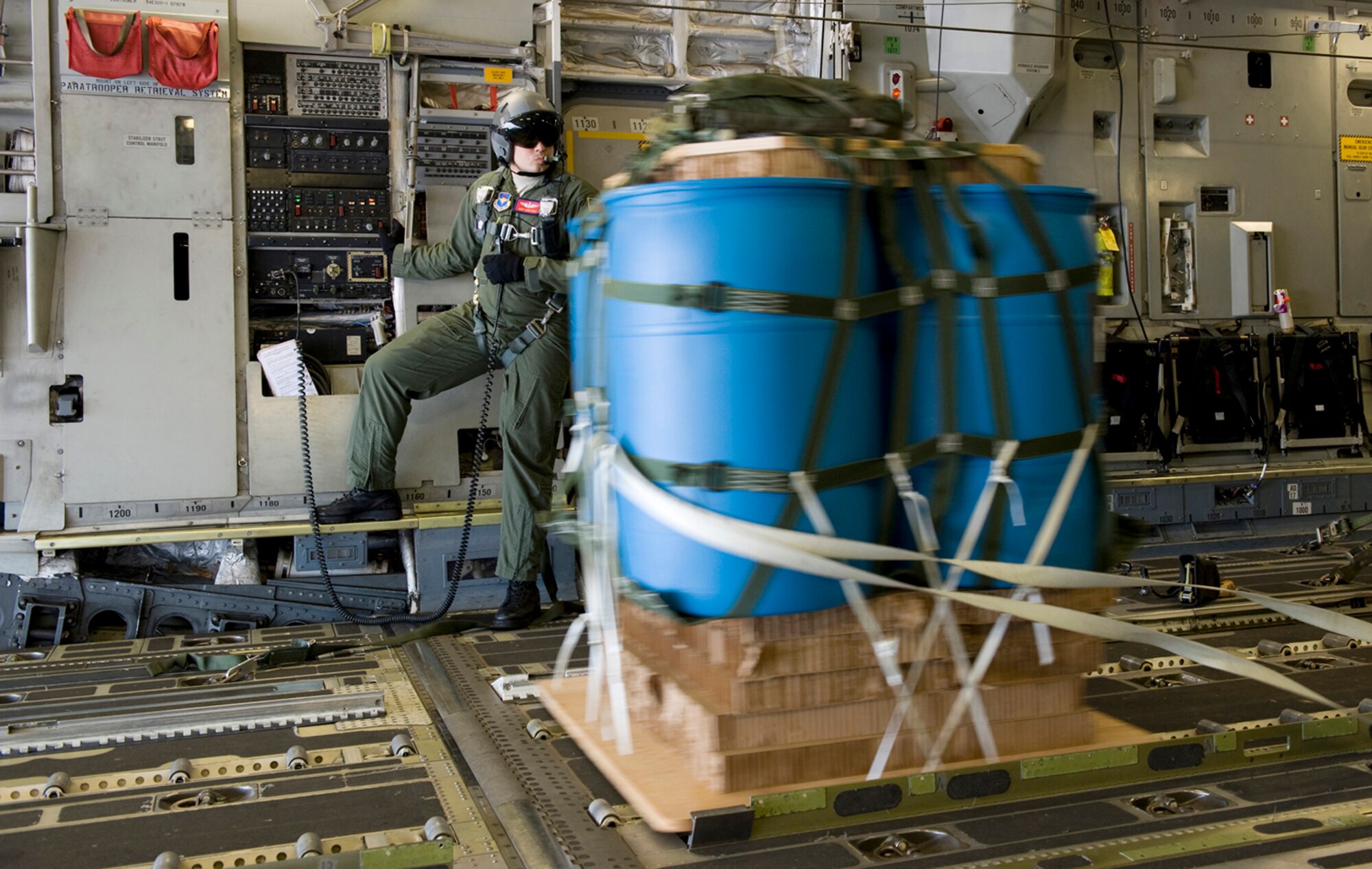 Staff Sgt. John Frisk watches a 1,000 pound cargo pallet leave the aircraft during a joint precision air drop system evaluation flight March 18, 2010, at Altus Air Force Base, Okla. Sergeant Frisk is a C-17 Globemaster III loadmaster with the 58th Airlift Squadron.(U.S. Air Force Photo/Master Sgt. Jack Braden)