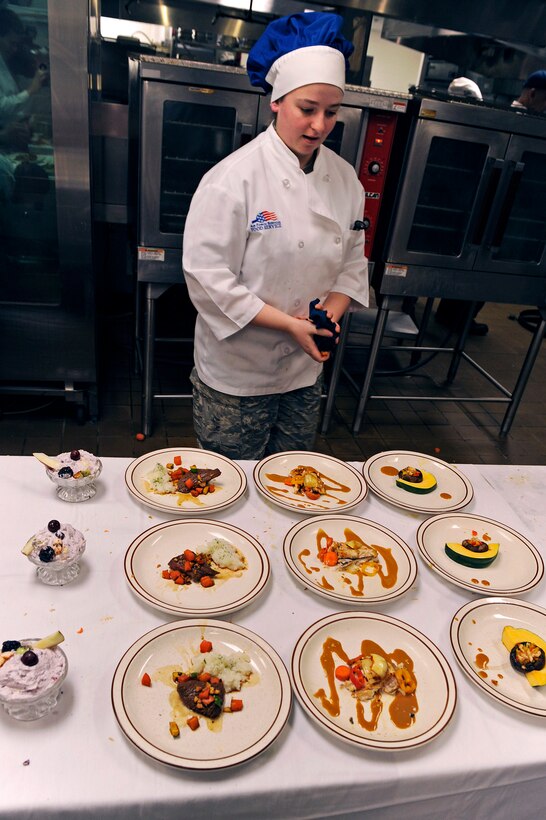 ELLSWORTH AIR FORCE BASE, S.D. -- Airman 1st Class Steffanie Whipple, 28th Force Support Squadron food services technician, does a final inspection of the dishes she and her team created during the second annual Ellsworth Iron Chef competition, March 17.  Their dishes consisted of stuffed mushrooms, Cajun fish, teriyaki steak and whipped fruit. (U.S. Air Force photo/Senior Airman Marc I. Lane)