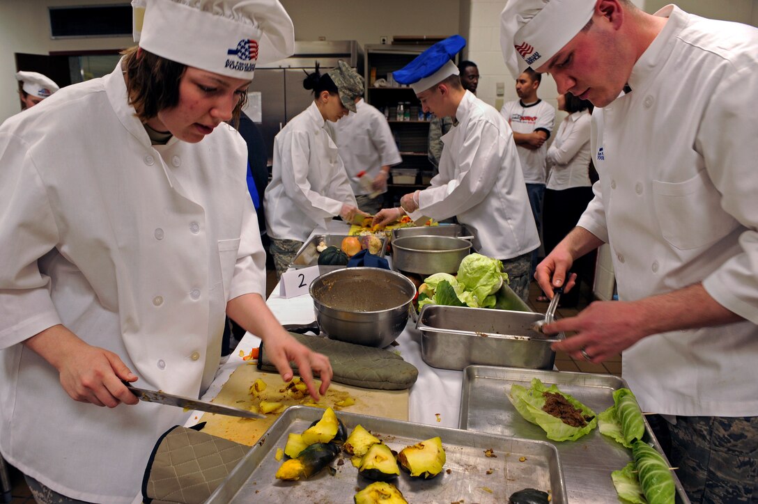 ELLSWORTH AIR FORCE BASE, S.D. -- Airman 1st Class Tiffany Lamb and Airman Resse Audette, 28th Force Support Squadron food services technicians, prepare an entrée and dessert for the second annual Ellsworth Iron Chef competition, March 17.   Airmen Lamb and Audette along with Airman 1st Class Brent Smith won the competition and were given professional knife sets as prizes. (U.S. Air Force photo/Senior Airman Marc I. Lane)