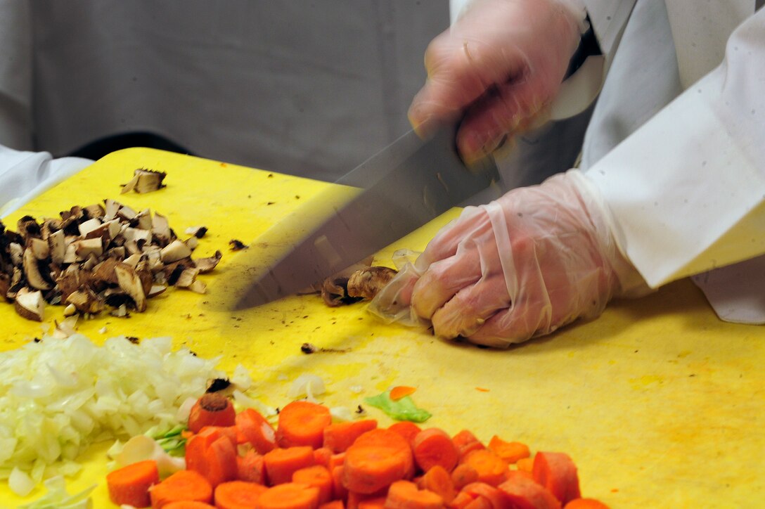 ELLSWORTH AIR FORCE BASE, S.D. -- Airman 1st Class Ashleigh Morford, 28th Force Support Squadron food services technician, chops mushrooms during the second annual Ellsworth Iron Chef competition, March 17.  The available ingredients were kept secret from the teams until the beginning of the competition. (U.S. Air Force photo/Senior Airman Marc I. Lane)

