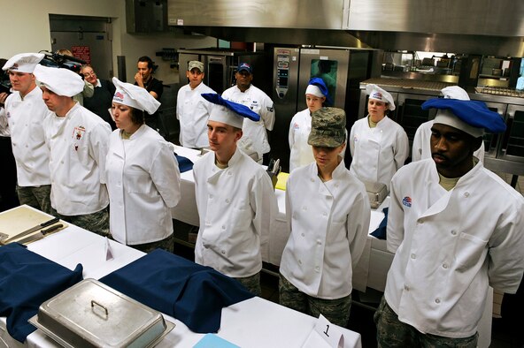 ELLSWORTH AIR FORCE BASE, S.D. -- Four, three-person, teams stand ready to begin the second annual "Ellsworth Iron Chef" competition, March 17. The teams had one hour to prepare three dishes using corned beef, milkfish, cabbage, peppers, mushrooms, fruits, parsnips, turnips and onions into an appetizer, entrée and dessert. (U.S. Air Force photo/Senior Airman Marc I. Lane)