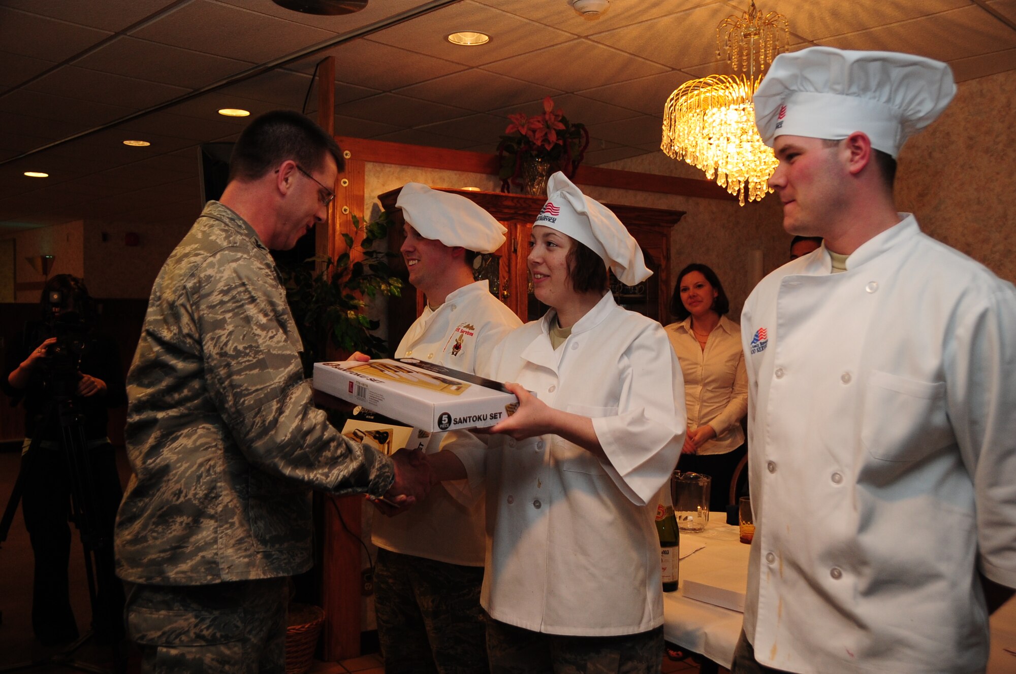 ELLSWORTH AIR FORCE BASE, S.D. -- (Left to right) Col. Steven Hiss, 28th Bomb Wing vice commander, presents Airmen 1st Class Tiffany Lamb and  Brent Smith, and Airman Reese Audette, 28th Force Support Squadron cooks, with a four-piece knife set during the Ellsworth Iron Chef competition, March 17.   The competition was an hour long competition between four teams preparing three dishes with an Irish twist. (U.S. Air Force photo/Airman 1st Class Anthony Sanchelli)
