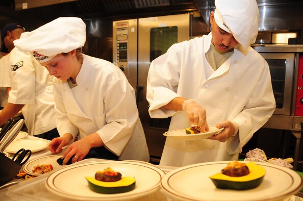ELLSWORTH AIR FORCE BASE, S.D. -- (Left to right) Airmen 1st Class Sarah Meador and Michael Azares, 28th Force Support Squadron cooks, put the final touches on their appetizers during the "Ellsworth Iron Chef" competition, March 17. The competition consisted of four teams competing against each other to complete three dishes in one hour. (U.S. Air Force photo/Airman 1st Class Anthony Sanchelli)