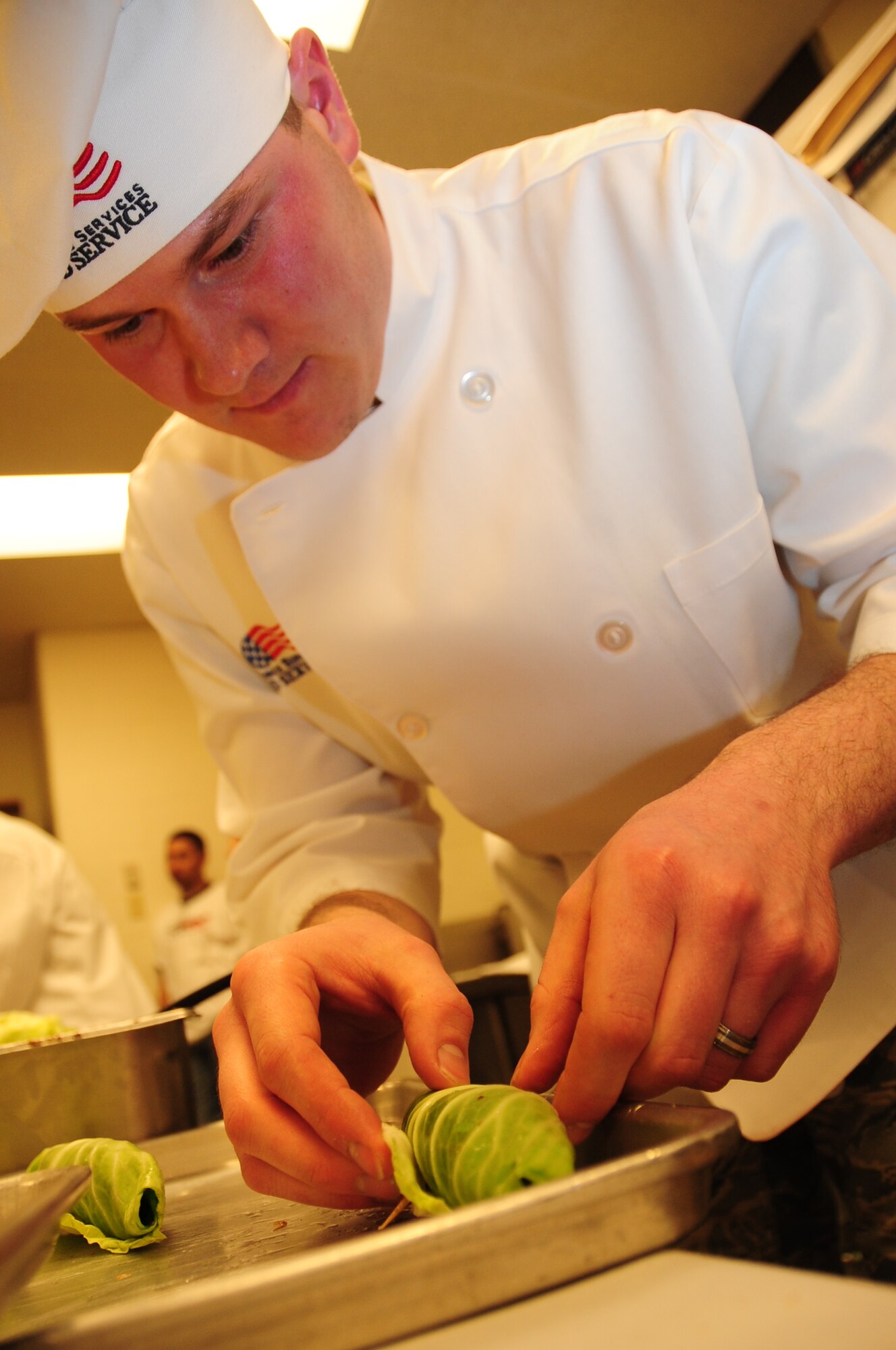 ELLSWORTH AIR FORCE BASE, S.D. -- Airman Resse Audette, 28th Force Support Squadron cook, wraps cabbage around corn beef during the Ellsworth Iron Chef competition, March 17.   Airman Audette created the appetizer for team two, who won the competition. (U.S. Air Force photo/Airman 1st Class Anthony Sanchelli)
