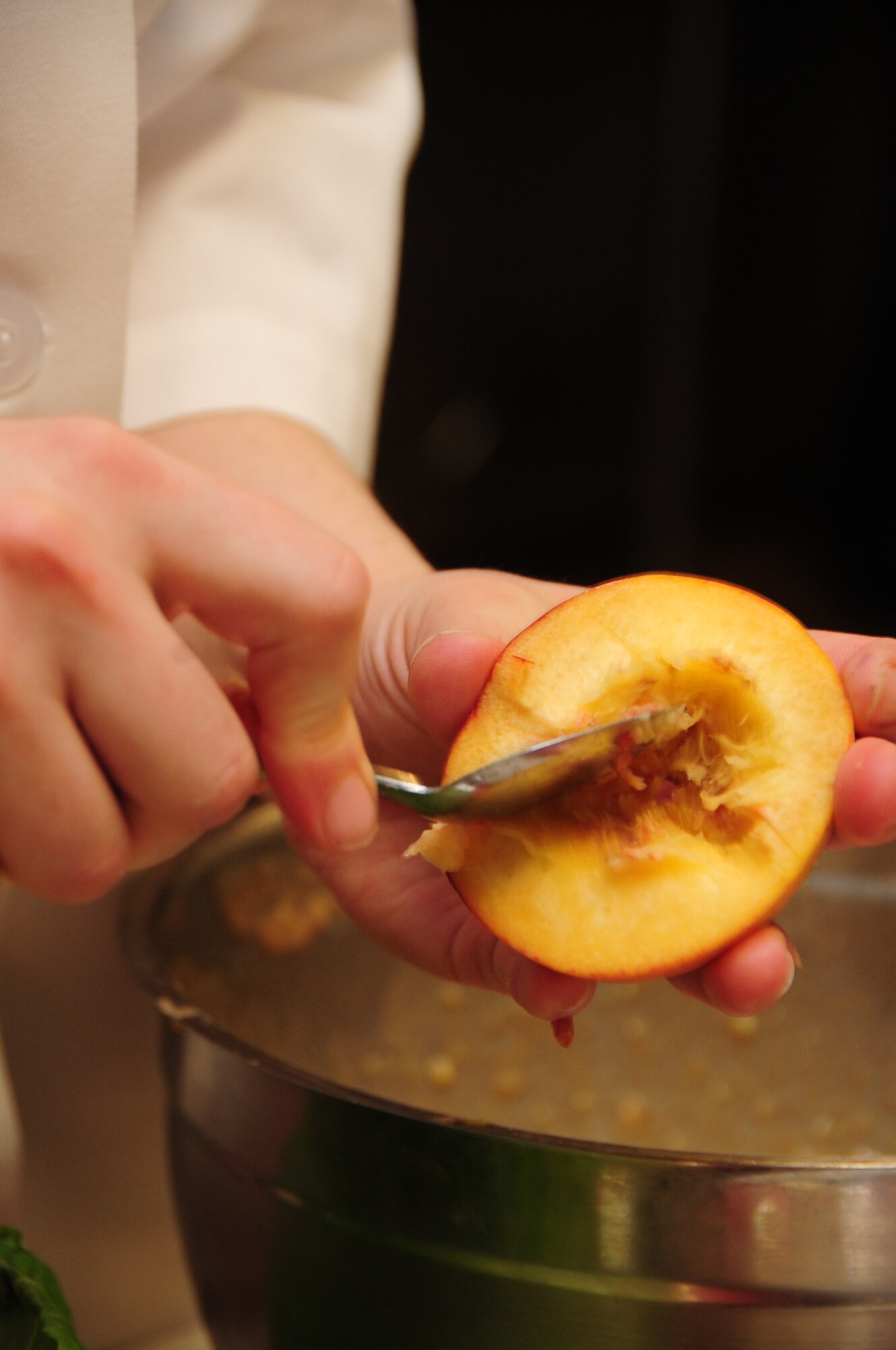 ELLSWORTH AIR FORCE BASE, S.D. -- Airman 1st Class Tiffany Lamb, 28th Force Support Squadron cook, scoops the seeds out of an apricot during the Ellsworth Iron Chef competition, March 17.   Airman Lamb used apricots in a cake, which also contained fish and a blackberry glaze.  The competition had an Irish twist as part of Saint Patrick's Day, each dish had to contain either milk fish or corned beef, including the dessert. (U.S. Air Force photo/Airman 1st Class Anthony Sanchelli)
