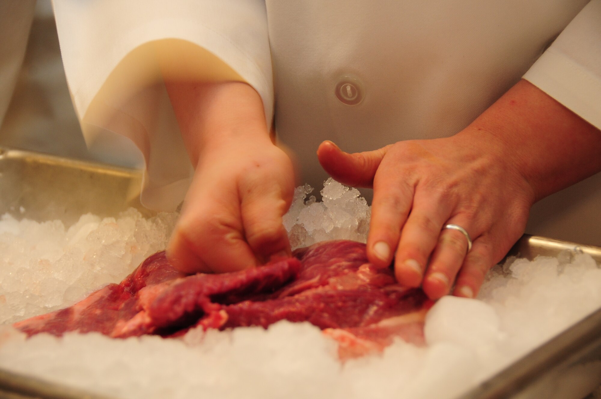ELLSWORTH AIR FORCE BASE, S.D. -- Airman 1st Class Sarah Meador, 28th Force Support Squadron cook, tenderizes  a slab of beef during the Ellsworth Iron Chef competition, March 17.   The competition consisted of four, three man teams.  The competition consisted of four, three- member teams and challenged contestants with a “secret ingredient,” either corned beef or milk fish in honor of St. Patrick’s Day. (U.S. Air Force photo/Airman 1st Class Anthony Sanchelli)
