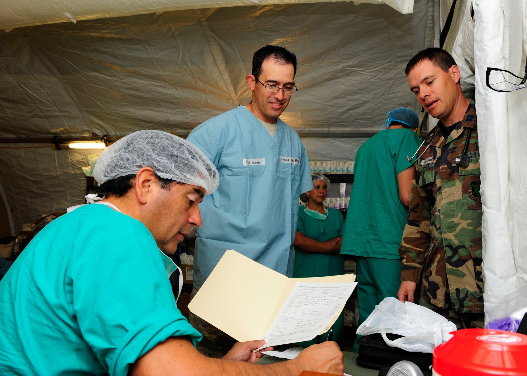 Tech. Sgt. Antonio Andrade (center) translates for a Chilean doctor (left) and Capt. Brian Lupfer (right) after a surgery in the expeditionary hospital March 16, 2010, in Angol, Chile. Sergeant Andrade is a translator for the Air Force Expeditionary Medical Support team here. He is a dental technician assigned to 336th Dental Squadron at Mountain Home Air Force Base, Idaho. Captain Lupfer is a physician's assistant assigned to the 359th Medical Group at Randolph Air Force Base, Texas. (U.S. Air Force photo/Senior Airman Tiffany Trojca)