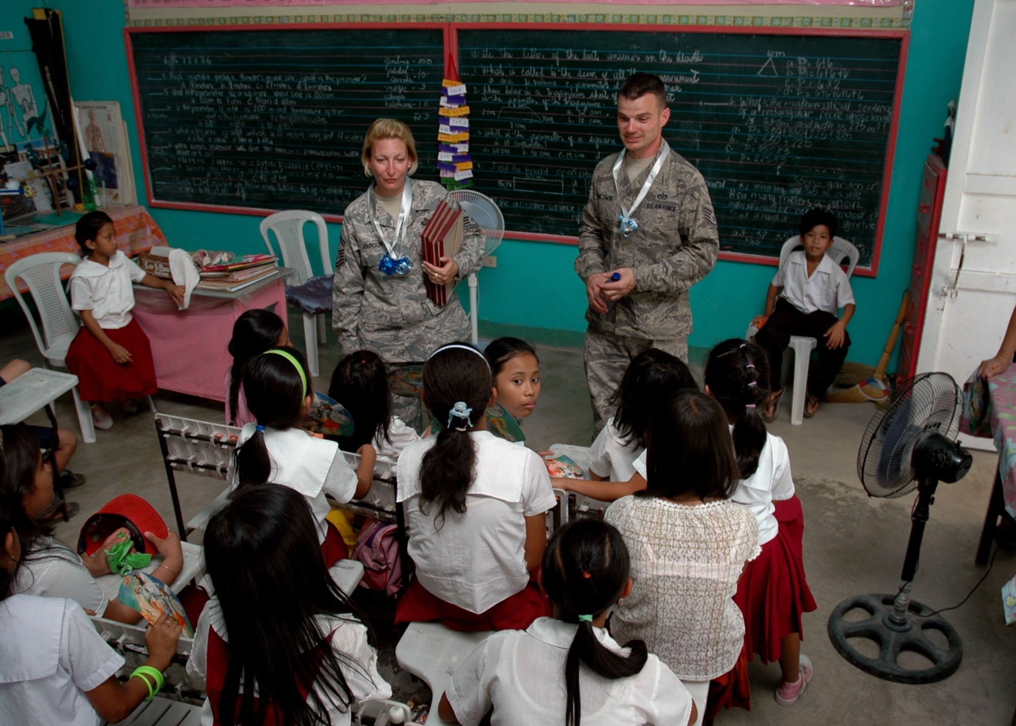 Senior Master Sgt. Nicole Johnson and Staff Sgt. Anthony Lenczowski visit a third-grade classroom at Sapang Bato Elementary School in Angeles City, Philippines, March 15, 2010, during a Balikatan 2010 community relations event. Sergeant Johnson is deployed from 13th Air Force at Joint Base Pearl Harbor Hickam, Hawaii, and Sergeant Lenczowski is from the 25th Air Support Operations Squadron at Wheeler Army Air Field, Hawaii.  They joined other military members from the United States and the Armed Forces of the Philippines to distribute clothing, hygiene products and toys to 1,700 students of various schools in the area. The visit took place during Balikatan 2010, an annual bilateral exercise involving the Philippine military, Philippine civil defense agencies and the U.S. military.  (U.S. Navy photo/Chief Petty Officer David M. Votroubek)