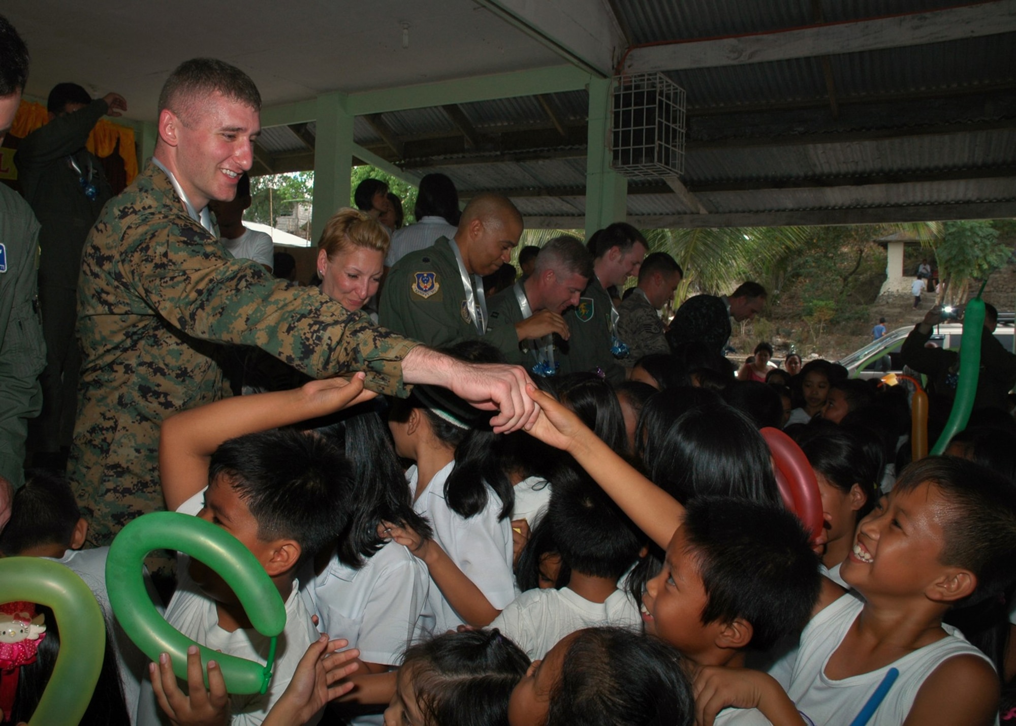 U.S. Marine Corps 2nd Lt. Scott Sasser joins other U.S. servicemembers in greeting students at Sapang Bato Elementary School during a community relations visit to the school in Angeles City, Philippines, March 15, 2010.  Lietuenant Sasser and other military members from the United States and the Armed Forces of the Philippines went to the school to distribute clothing, hygiene products and toys to the 1,700 students in the area. The visit took place during Balikatan 2010, an annual bilateral exercise involving the Philippine military, Philippine civil defense agencies and the U.S. military.  (U.S. Navy photo/Chief Petty Officer David M. Votroubek)