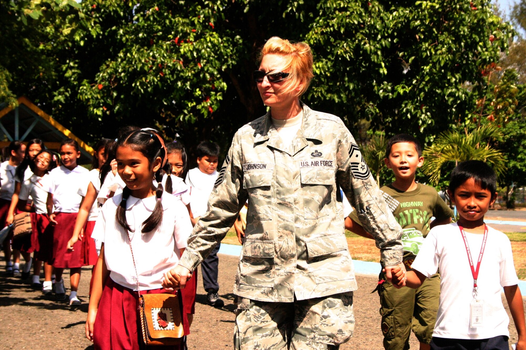 Senior Master Sgt. Nicole Johnson, first sergeant for the U.S. Air Force personnel at Balikatan 2010, leads Philippine students from Sapang Bato Elementary School in Angeles City to the flight line at Clark, Philippines, March 15.  Sergeant Johnson is deployed to the exercise from 13th Air Force at Joint Base Pearl Harbor Hickam, Hawaii.  About 300 students visited the flight line as part of an Armed Forces of the Philippines community outreach program during Balikatan 2010, an annual bilateral training exercise designed to increase interoperability between the Philippine and U.S. militaries.  (U.S. Marine Corps photo/Gunnery Sgt. Cindy Fisher)