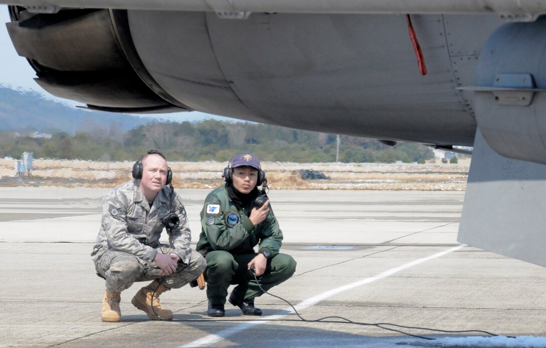 Staff Sgt. Robert Ensley waits to conduct a pre-flight inspection with Japan Air Self Defense Force crewchief Senior Airman Naoki Yamashita March 11, 2010, at Tsuiki Air Base, Japan. Sergeant Ensley is a 35th Aircraft Maintenance Squadron crewchief. (U.S. Air Force photo/Staff Sgt. Rachel Martinez)