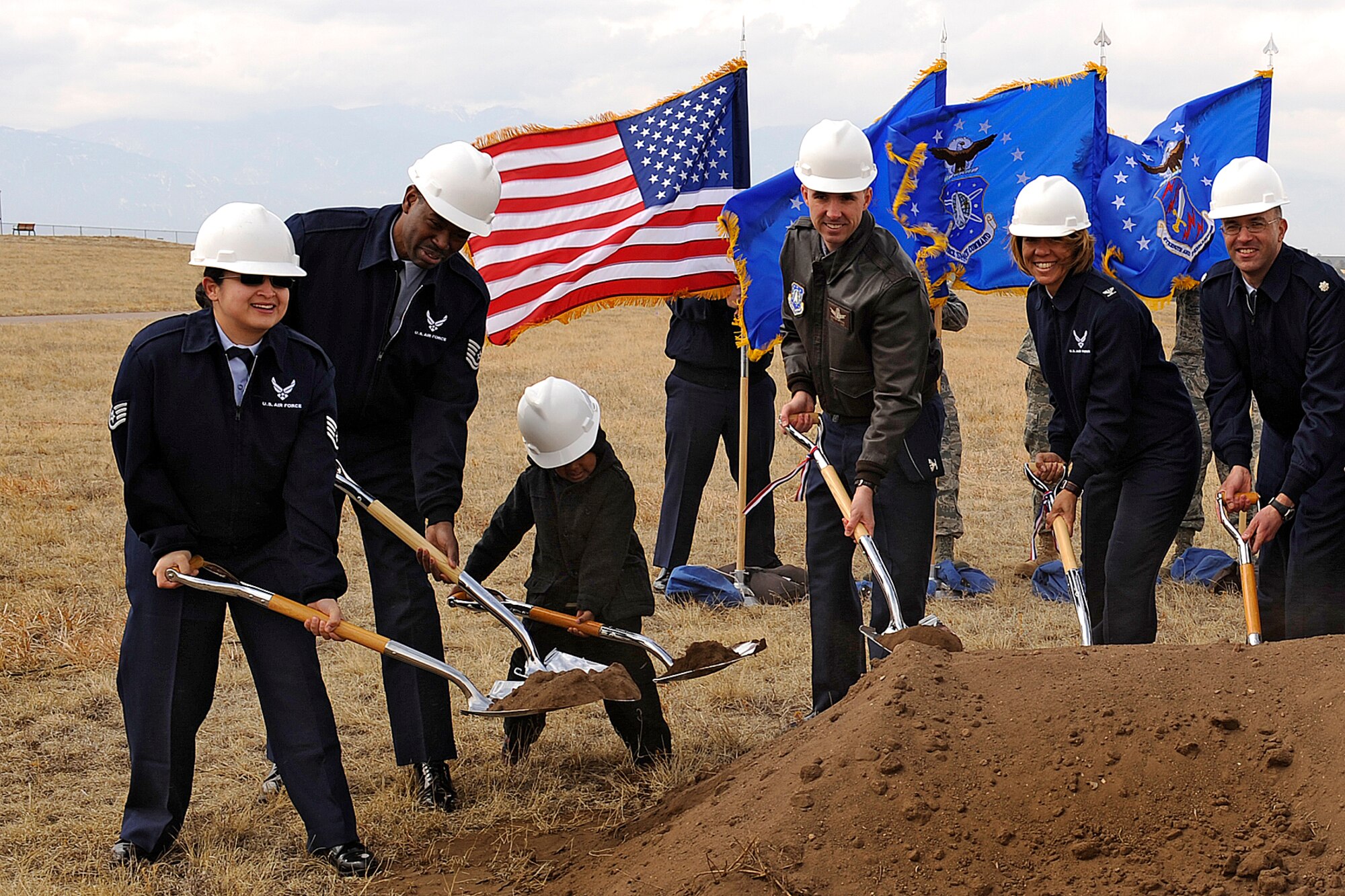 (From left) Staff Sgt. Marlene Locks, 3rd Space Operations Squadron at Schriever AFB, Tech. Sgt. Lonnie Locks, 21st Civil Engineer Squadron, and their four-year-old son Quentin Locks, join Peterson Air Force Base senior leaders Col. Stephen N. Whiting, 21st Space Wing commander, Col. Emily Buckman, 21st Mission Support Group commander, and Lt. Col. John Silverman, 21st Force Support Squadron commander, breaking ground on the Peterson East child development center March 8. Located across from the base exchange and commissary, the $8.1 million project is being funded by the American Recovery and Reinvestment Act of 2009. The Peterson East CDC will accommodate 192 children, increasing the wing’s ability to provide high-quality child care to servicemembers stationed here and is expected to open in August 2011. The 25,000 square-foot facility will be built using the Leadership in Energy and Environmental Design Silver design criteria and include solar hot water heating, solar window shades and low water landscaping. (U.S. Air Force photo/Craig Denton)