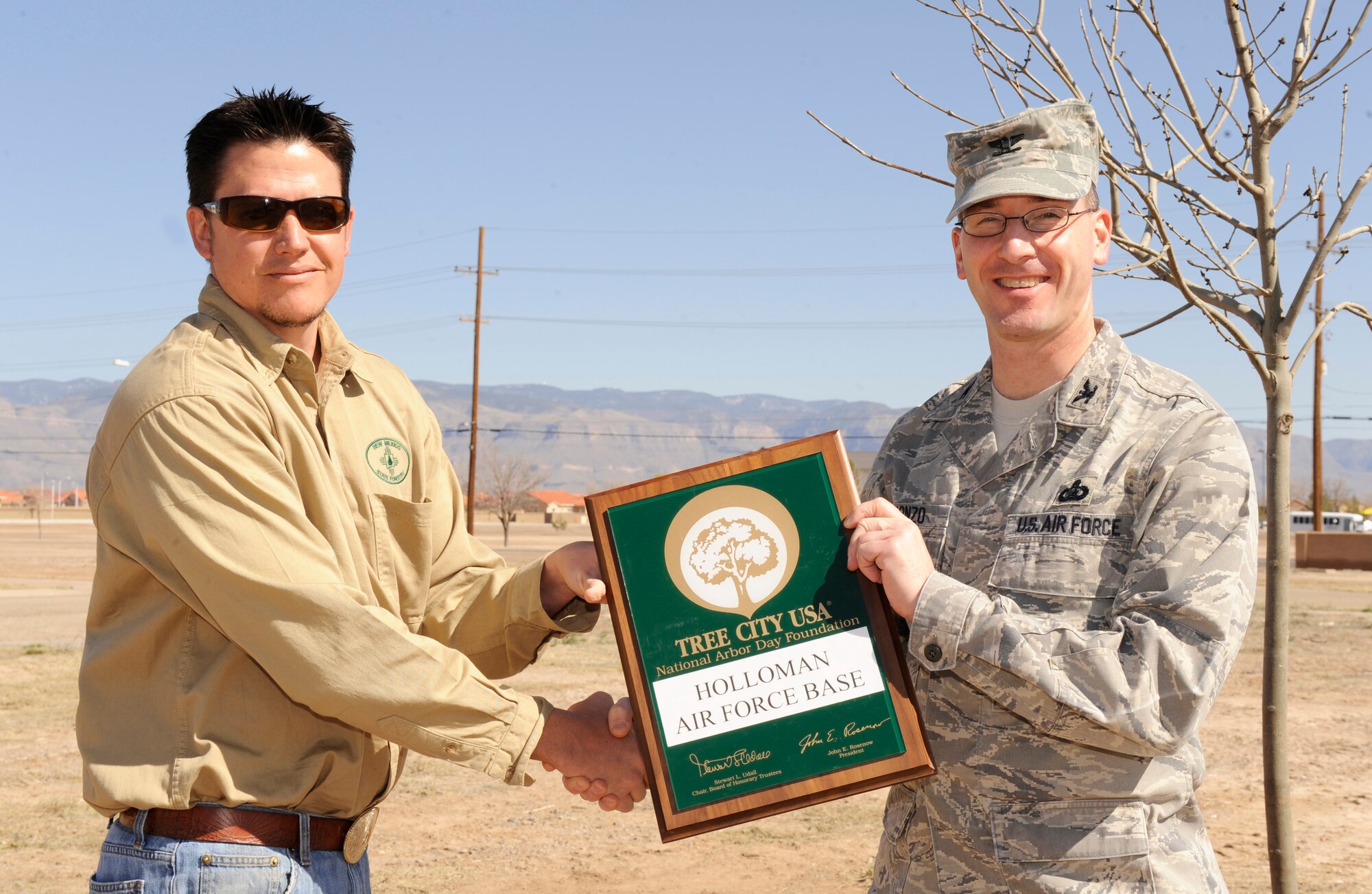 HOLLOMAN AIR FORCE BASE, N.M. -- Col. Stephen DiFonzo, 49th Mission Support Group commander, receives a Tree City USA plaque from Andrew Frederick, New Mexico State Forestry timber management officer, during the annual Arbor Day event March 12, 2010. Colonel DiFonzo participated in helping members of the Arbor Day Foundation plant a tree for the annual and worldwid celebrated Arbor Day. (U.S. Air Force photo by Airman 1st Class Eileen Payne)