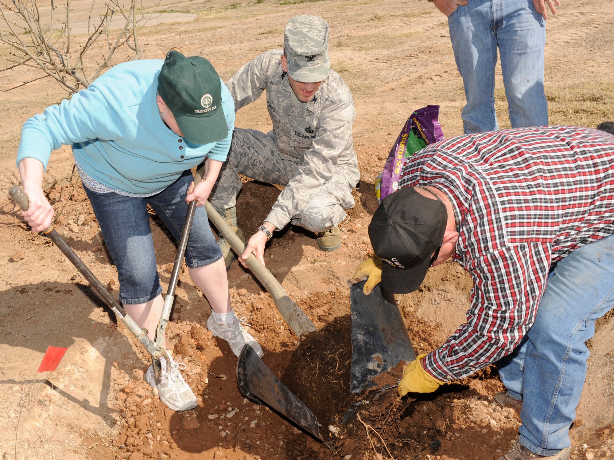 HOLLOMAN AIR FORCE BASE, N.M. -- Col. Stephen DiFonzo, 49th Mission Support Group commander, with Ellen Roderick, base environmental management system coordinator, and Lucas Oligschlaeger base natural resource biologist, begin to plant a tree across the street from the officer's club for the annual Arbor Day event March 12, 2010. Holloman has been awarded Tree City USA status for the last six years by the Arbor Day Foundation and has been a part of the celebration of Arbor Day. (U.S. Air Force photo by Airman 1st Class Eileen Payne)