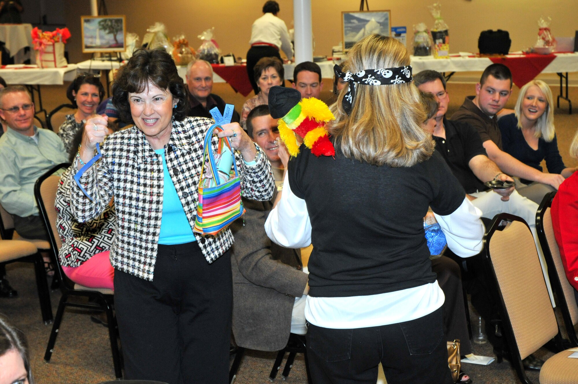 Janice Barnett claims her door prize, a gift card to a children’s clothing store, during Saturday’s Keesler Spouses Club auction.  Her husband is retired Col. Wayne Barnett.  (U.S. Air Force photo by Adam Bond)