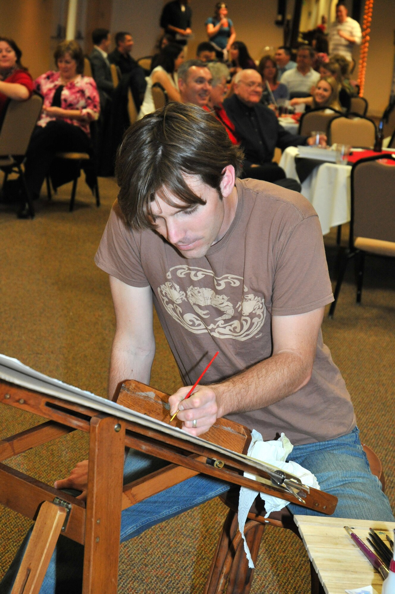 Ocean Springs artist Paul Weaver works on a watercolor painting to be put up for bids at the auction, a KSC fundraiser for scholarships and other charitable causes.  (U.S. Air Force photo by Adam Bond)
