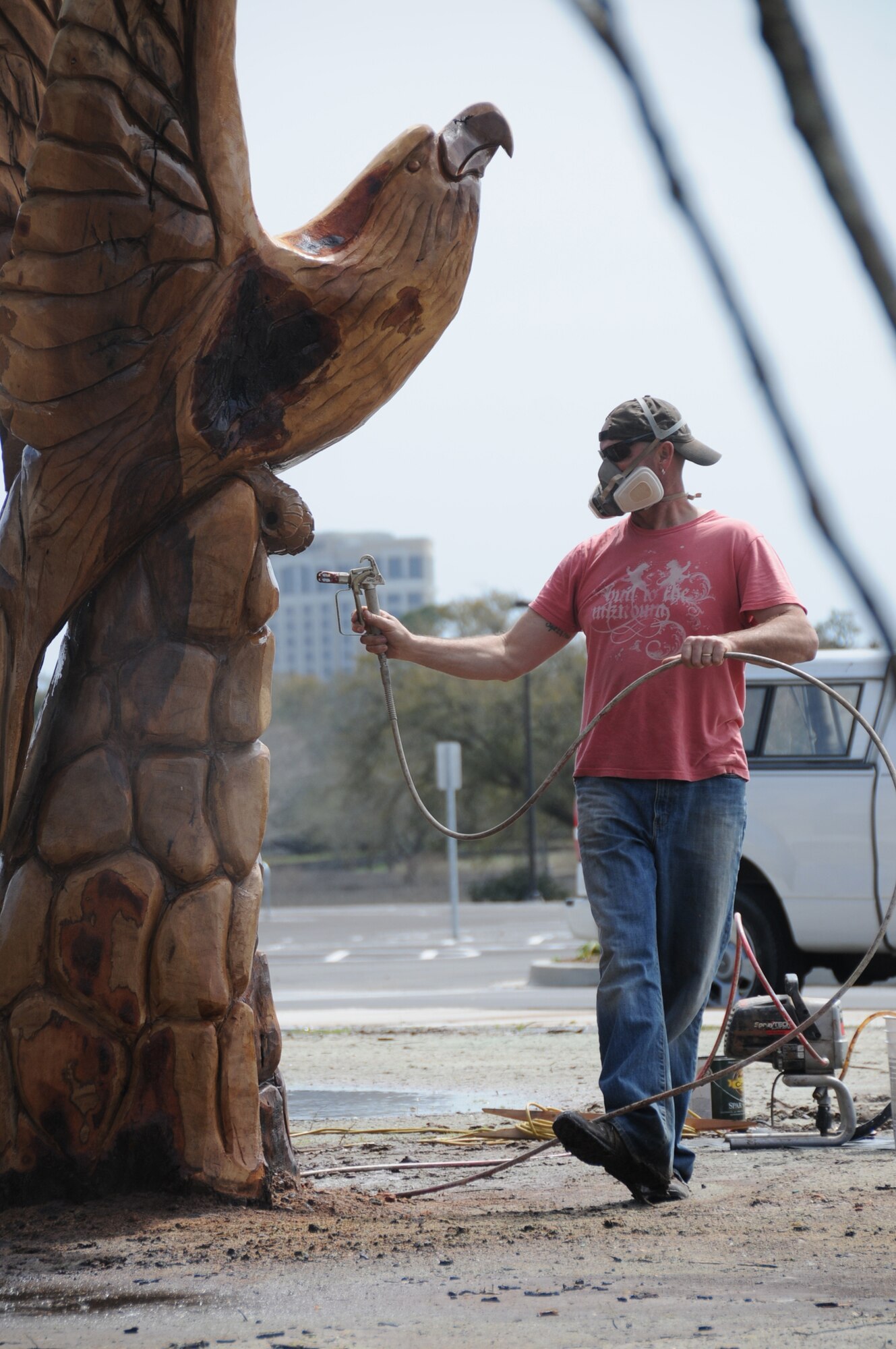 Marlin Miller sprays a final coat of varnish on the eagle he created in front of Keesler’s new exchange and commissary complex.  (U.S. Air Force photo by Kemberly Groue)