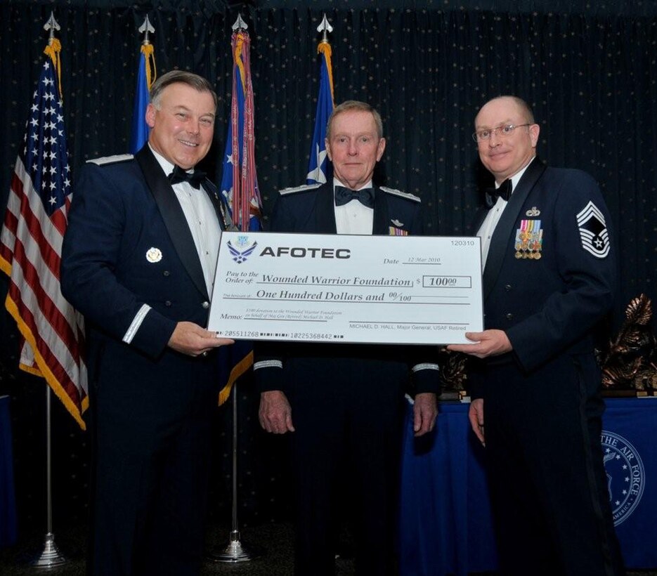 Air Force Operational Test and Evaluation Center Commander Maj. Gen. Stephen T. Sargeant (left) presents Maj. Gen. Michael D. Hall (retired) a donation to the Wounded Warrior Foundation in his name in appreciation for being a guest speaker at the March 26, 2009 AFOTEC Annual Awards Banquet. AFOTEC Chief Enlisted Manager CMSgt. Kelly Branscom (right) assists in the presentation. More than 185 AFOTEC member were recognized as outstanding performers for 2009.