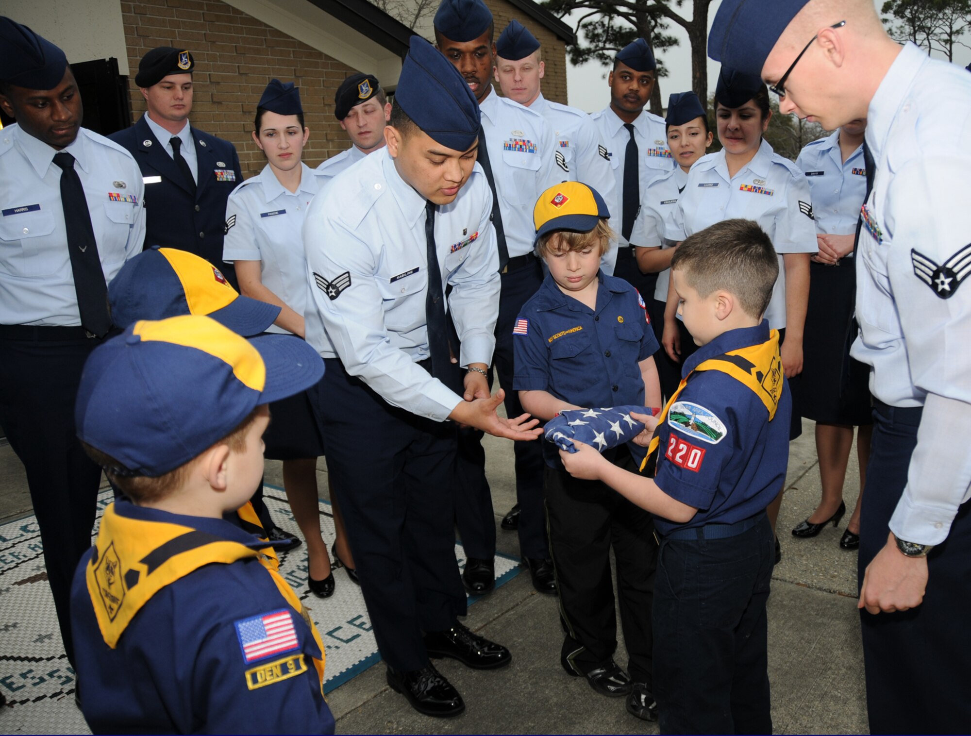 Senior Airman Henry Kabiling, an Airman Leadership School student from the 81st Medical Support Squadron, shows 8-year-old Caleb Self and other members of Cub Scout Pack 220 of Ocean Springs the proper way to hold the flag.  Airman Kibling and other ALS students showed how a flag folding ceremony is conducted at retreat ceremonies March 8 in front of the ALS Building.  Caleb’s parents are Eve Williams and James Self.  Learning proper flag etiquette is a requirement for the Scouts’ Wolf Badge.  (U.S. Air Force photo by Kemberly Groue)


