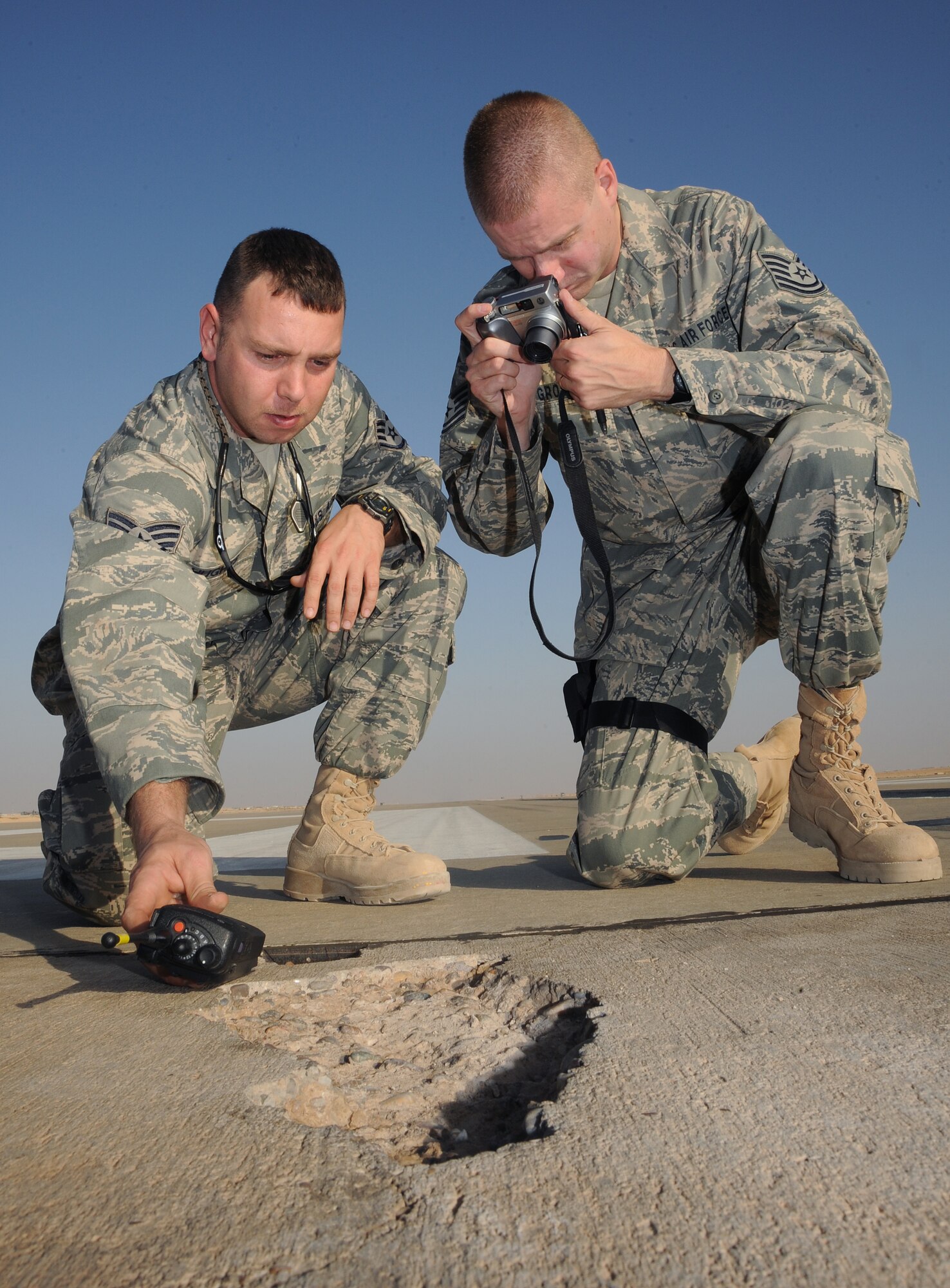 Staff Sgt. Robert Hughes, left, and Sergeant Gross photograph damage to the runway at Al Asad, Nov. 12.  (U.S. Air Force photo by Tech Sgt. Johnny Saldivar)
